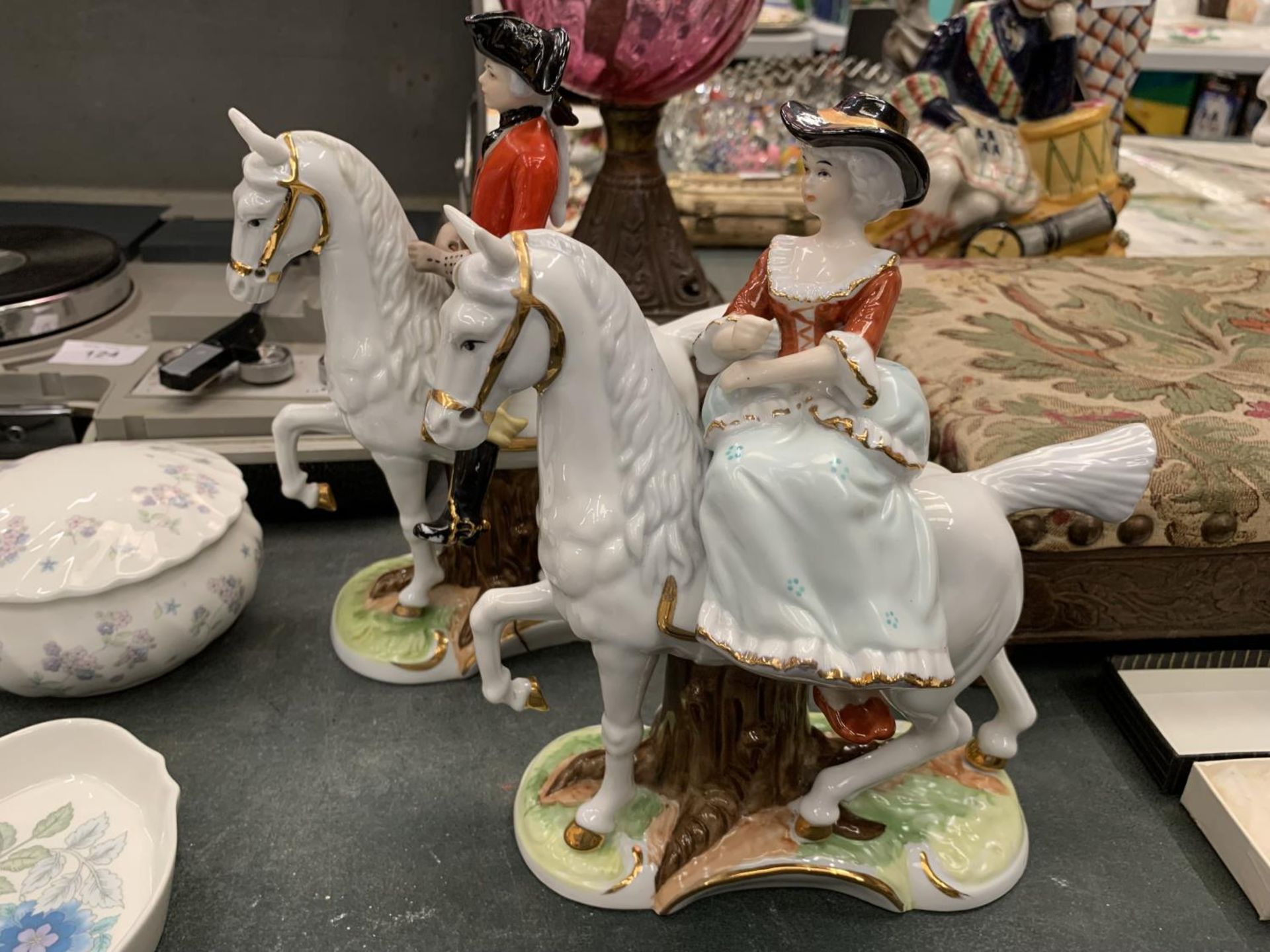 TWO CERAMIC FIGURES OF A MAN AND LADY OUT RIDING HEIGHT 21CM