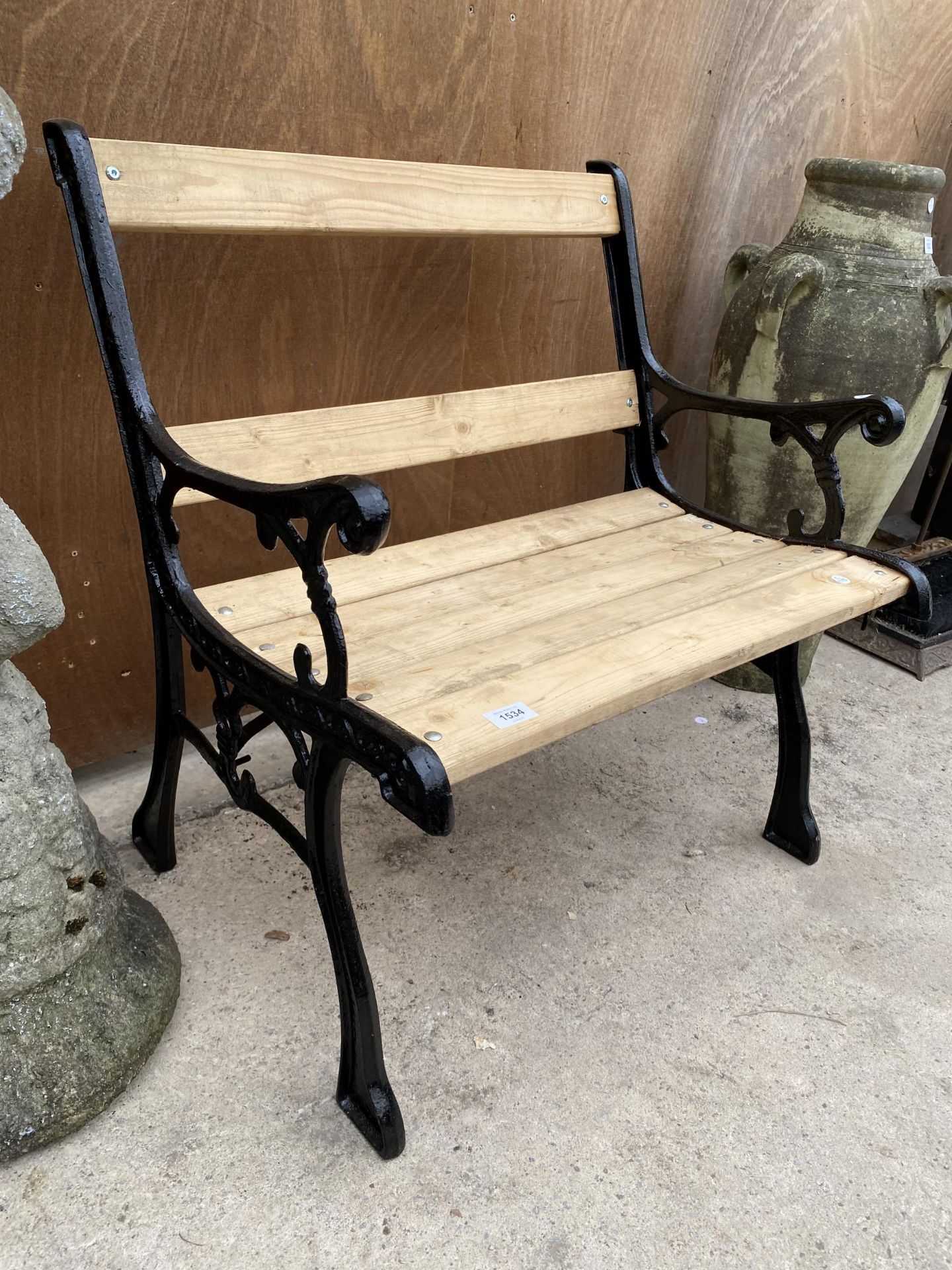 A WOODEN SLATTED WIDE GARDEN CHAIR WITH CAST IRON ENDS - Image 4 of 4