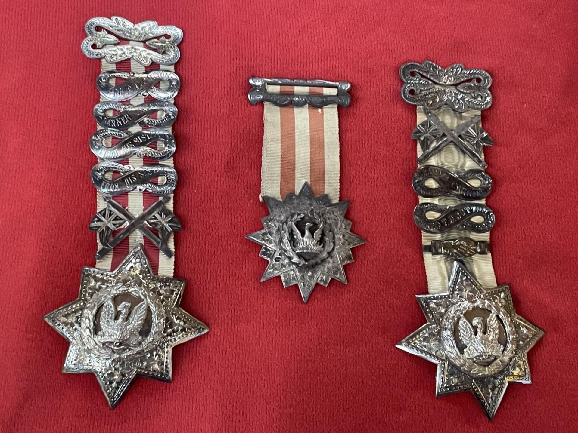 THREE MARKED SILVER MEDALS ON A BOARD