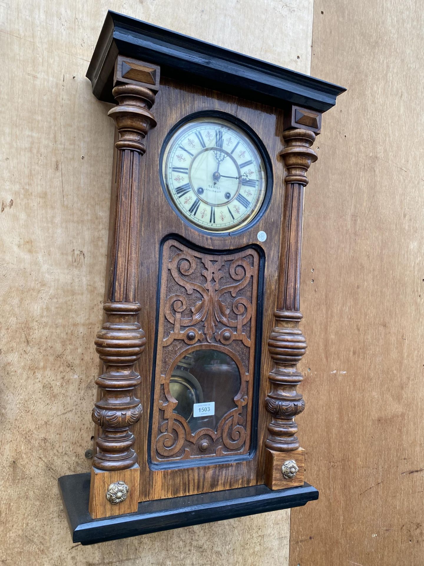 A LARGE WOODEN WALL CLOCK BEARING THE NAME 'SEWILL'