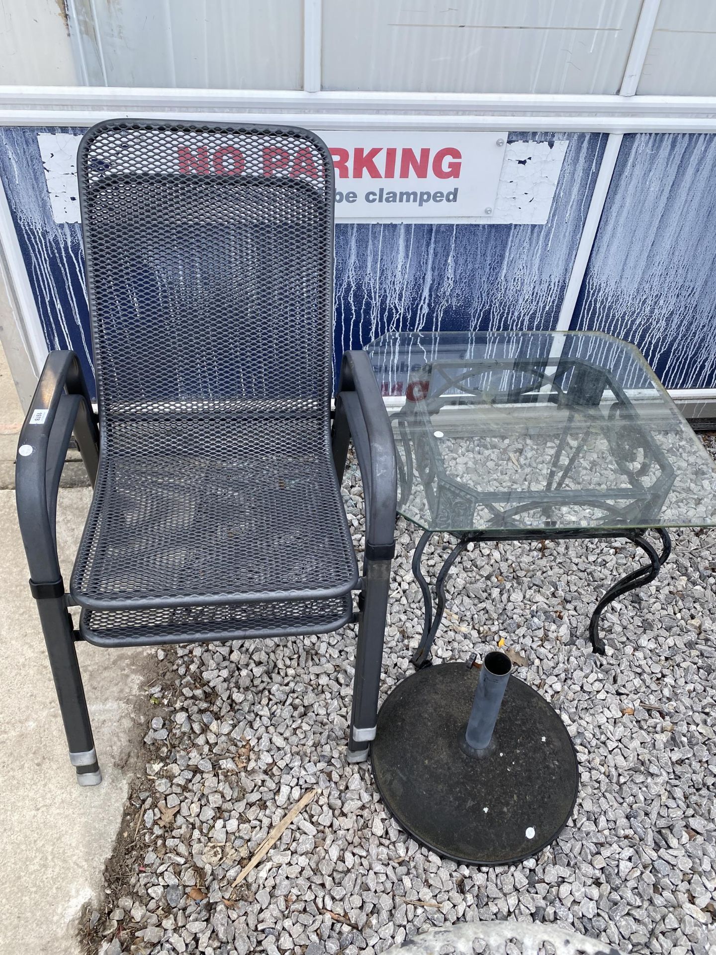 TWO STACKING GARDEN CHAIRS AND A GLASS TOPPED TABLE