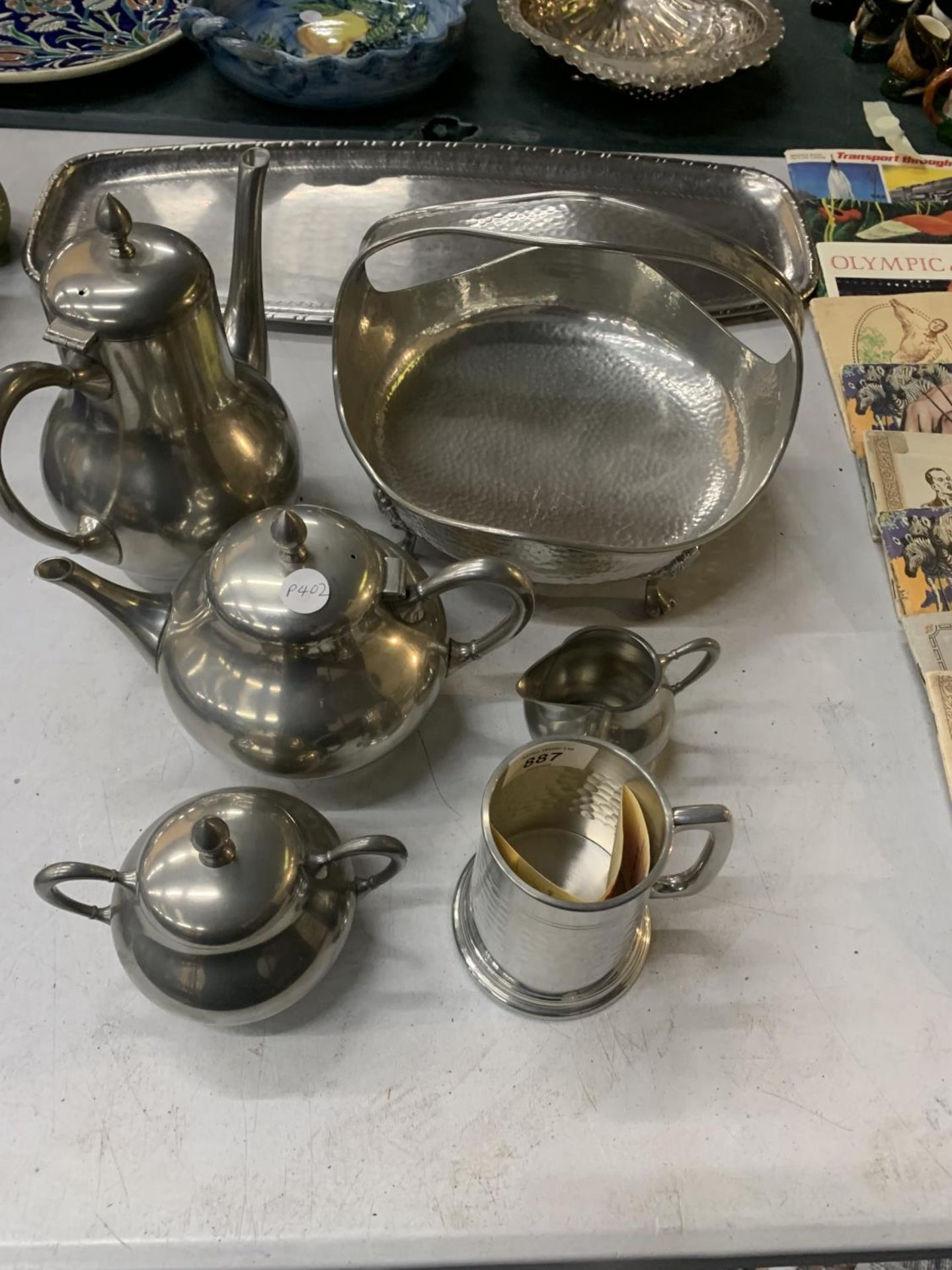 A PEWTER TEASET TO INCLUDE A TEAPOT, HOT WATER POT, CREAM JUG, SUGAR BOWL, A TRAY, LIDDED BASKET