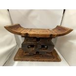 AN ORIENTAL WOODEN HEAD REST WITH CARVED 'X' DESIGN