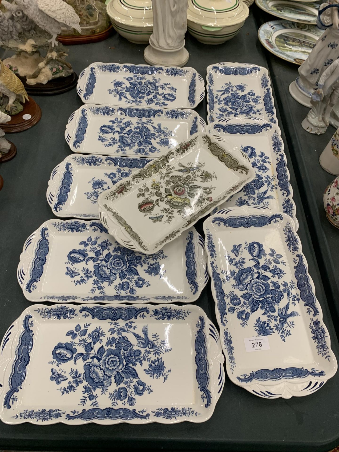 A SET OF EIGHT BLUE AND WHITE FLORAL DESIGN TRAYS AND FURTHER CERAMIC TRAY