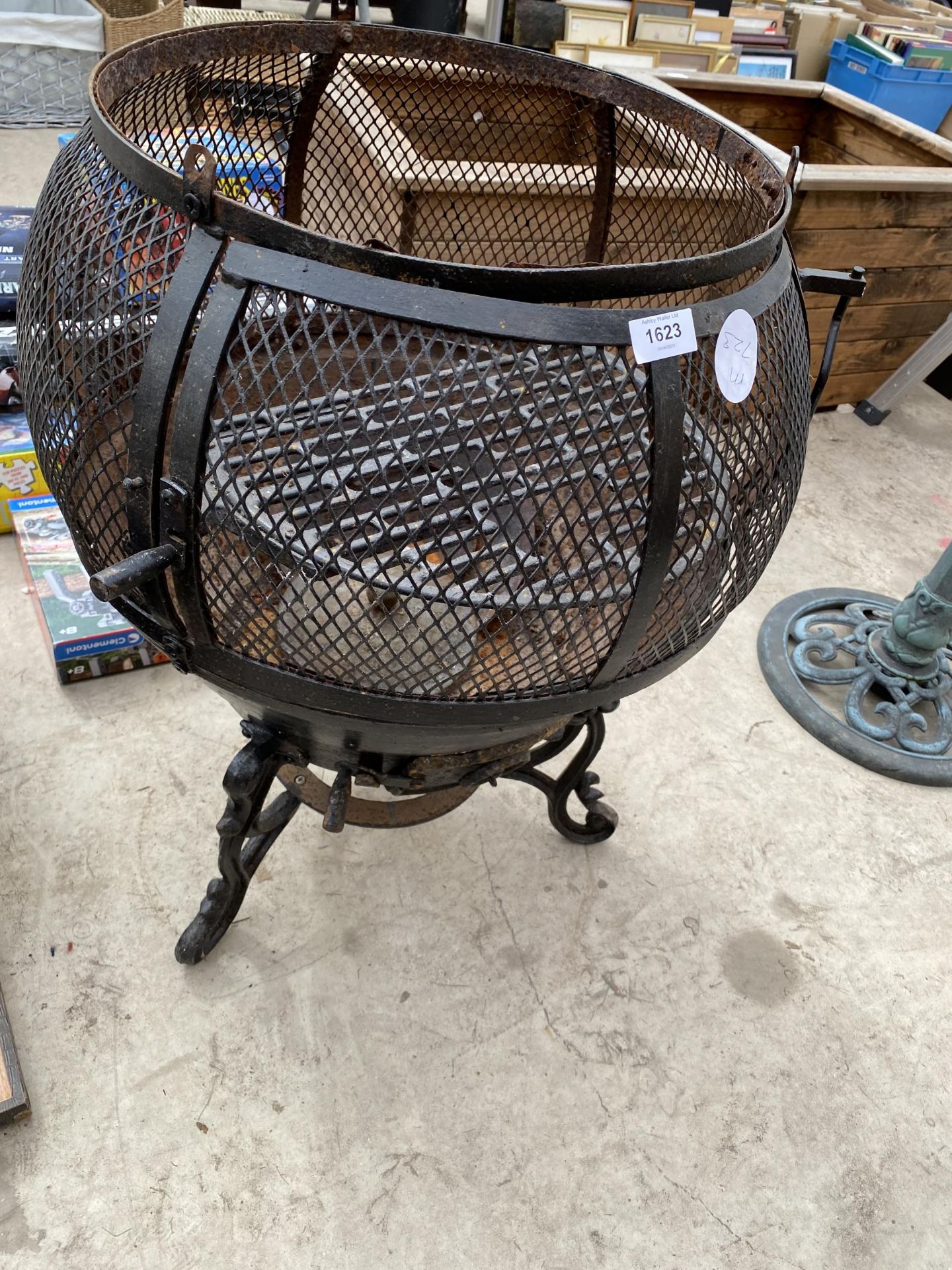 A METAL FIRE PIT WITH PIZZA SHELF