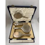 A CASED HALLMARKED SILVER BACKED FOUR PIECE DRESSING TABLE SET WITH FLORAL DESIGN