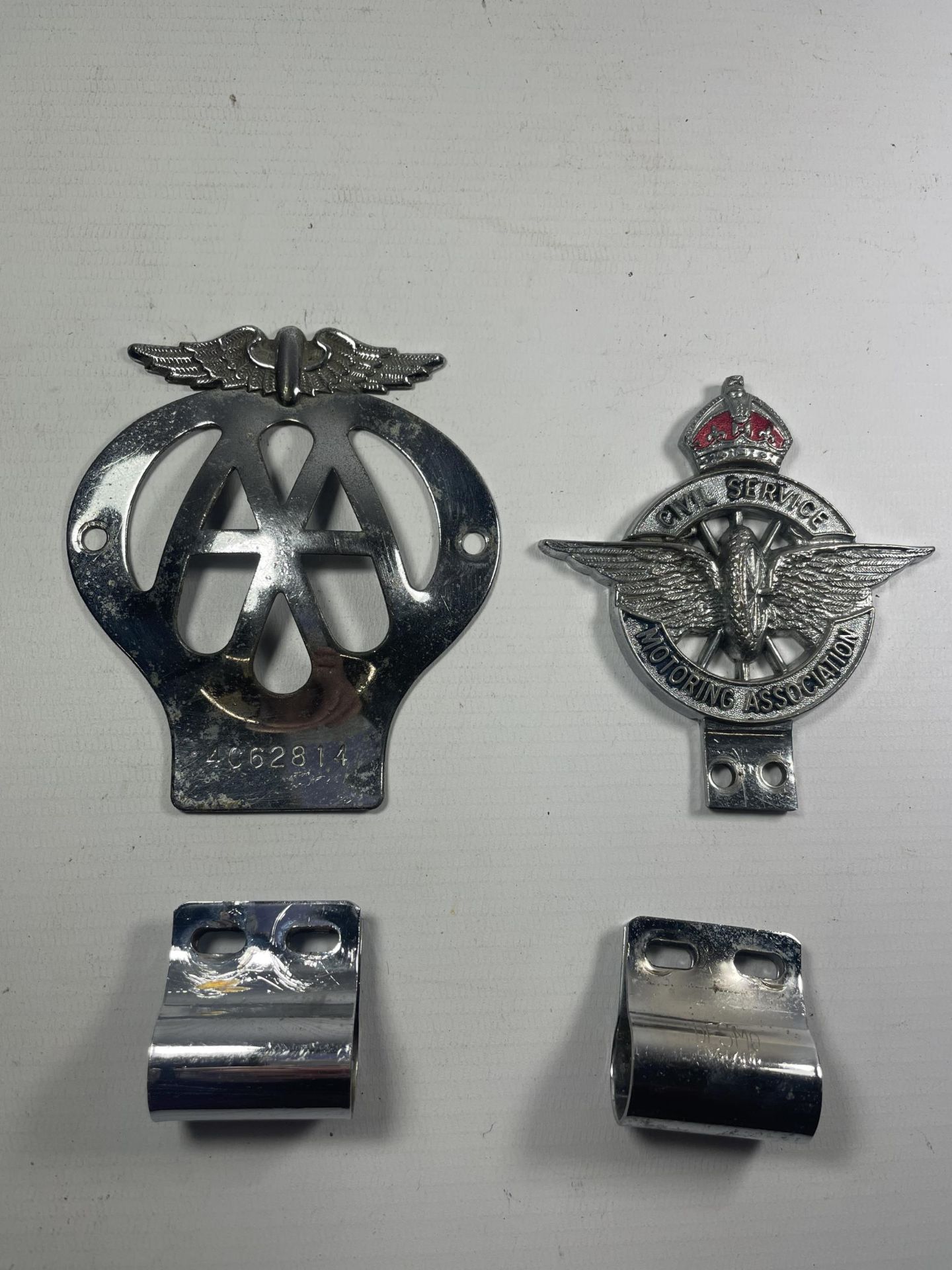 TWO VINTAGE BUMPER BADGES WITH CLIPS TO INCLUDE AN AA NO. 4C62814 AND A CIVIL SERVICE MOTORING