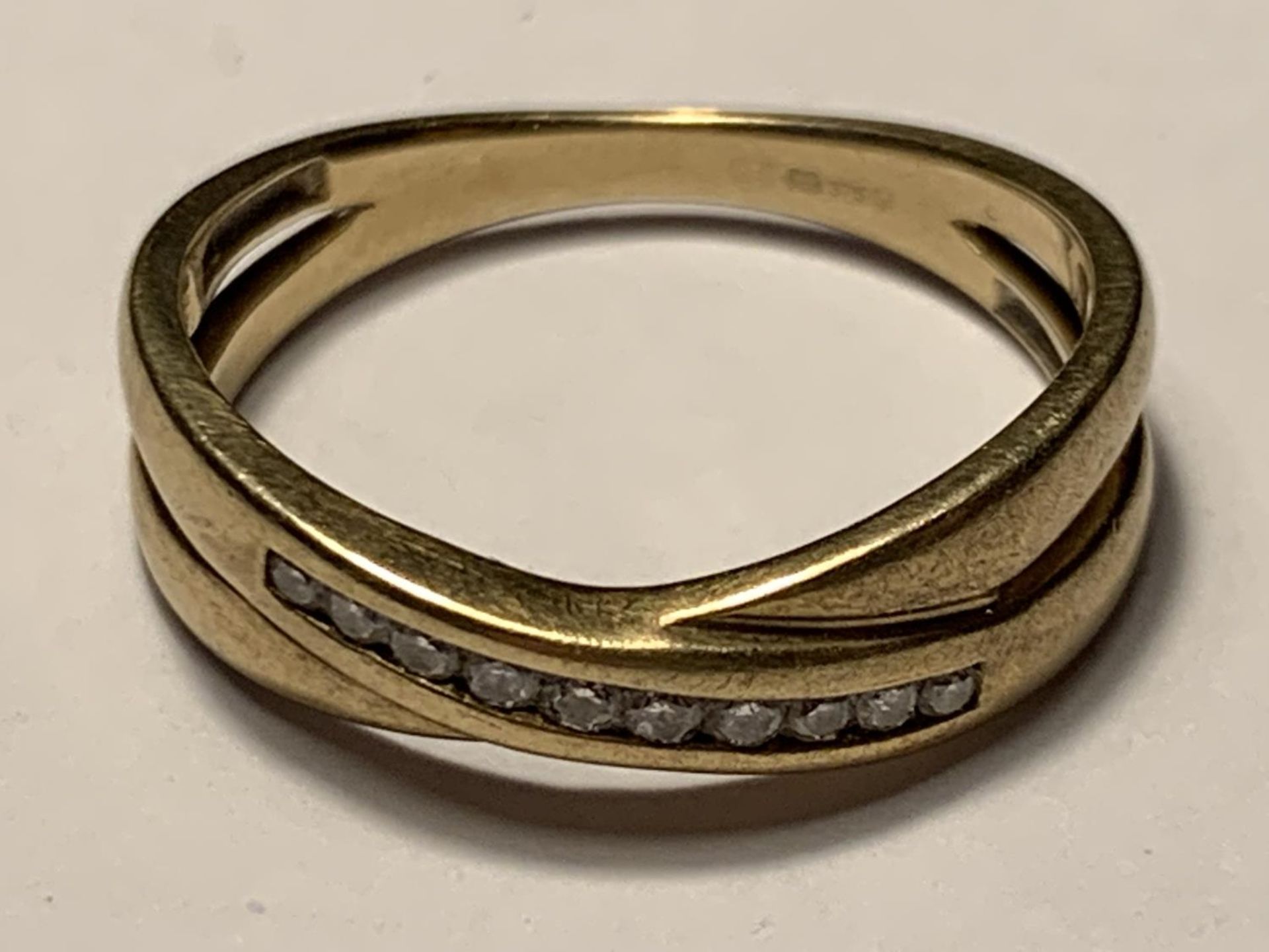 A 9 CARAT GOLD RING IN A CROSSOVER DESIGN SIZE N/0