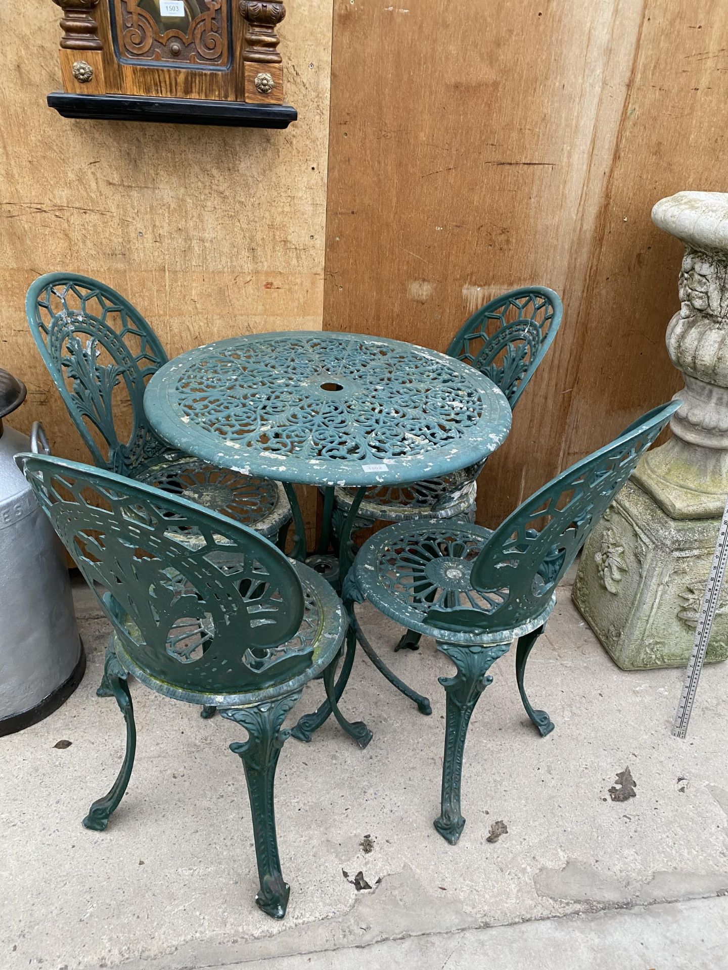 A VINTAGE CAST ALLOY BISTRO SET COMPRISING OF A ROUND TABLE AND FOUR CHAIRS