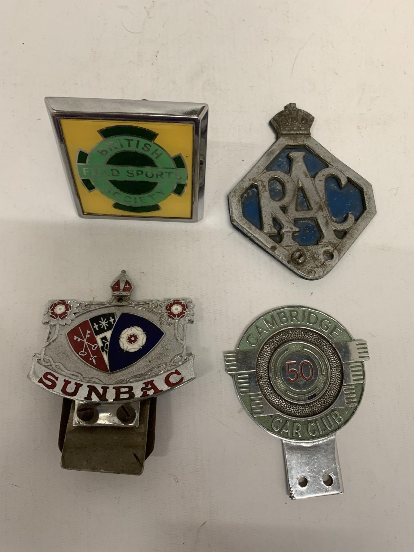 A GROUP OF FOUR VINTAGE CAR BADGES - RAC, AA, BRITISH FIELD SPORTS SOCIETY AND SUNBAC