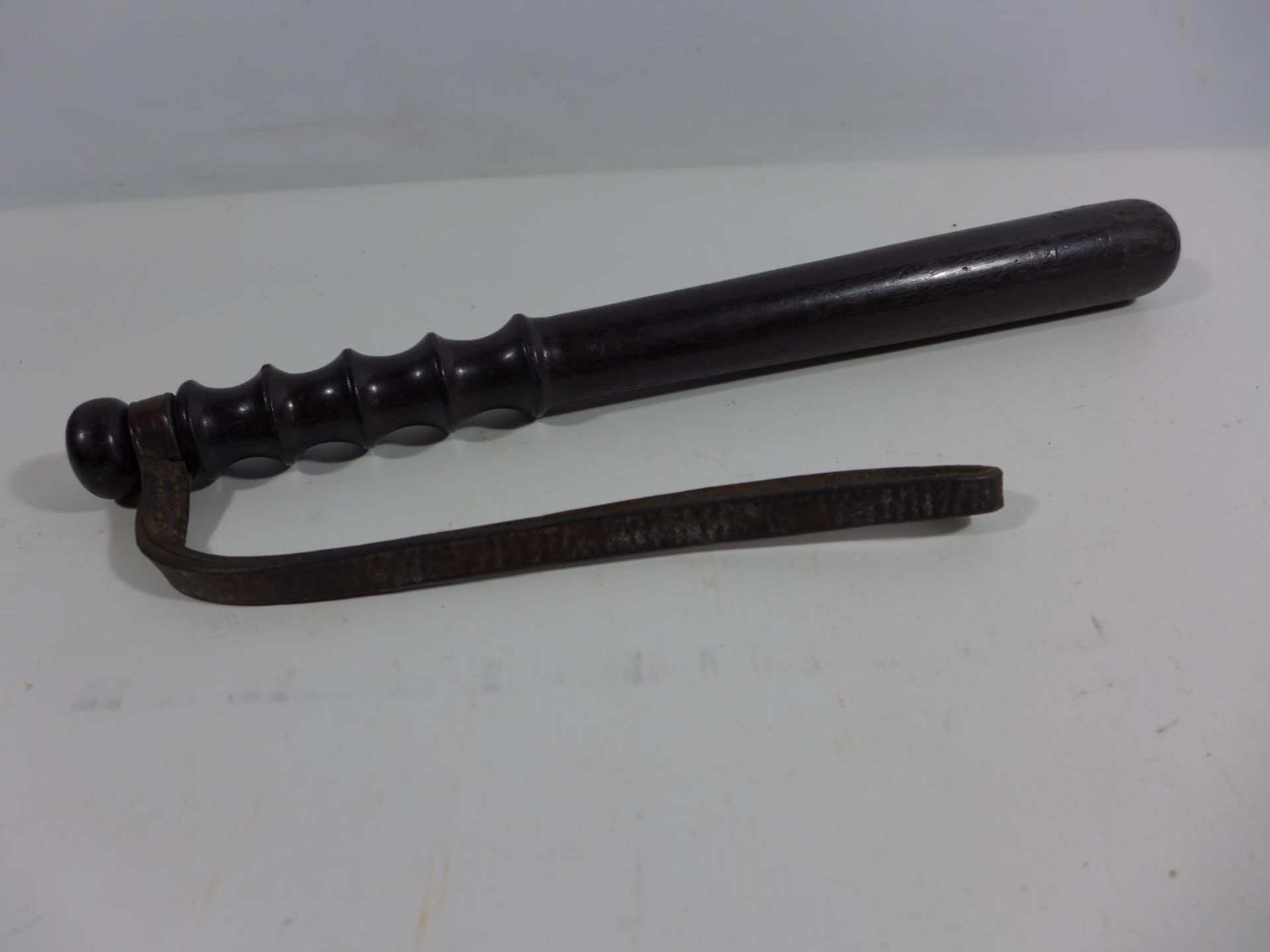 A POLICE TRUNCHEON AND LEATHER STRAP, LENGTH 38CM