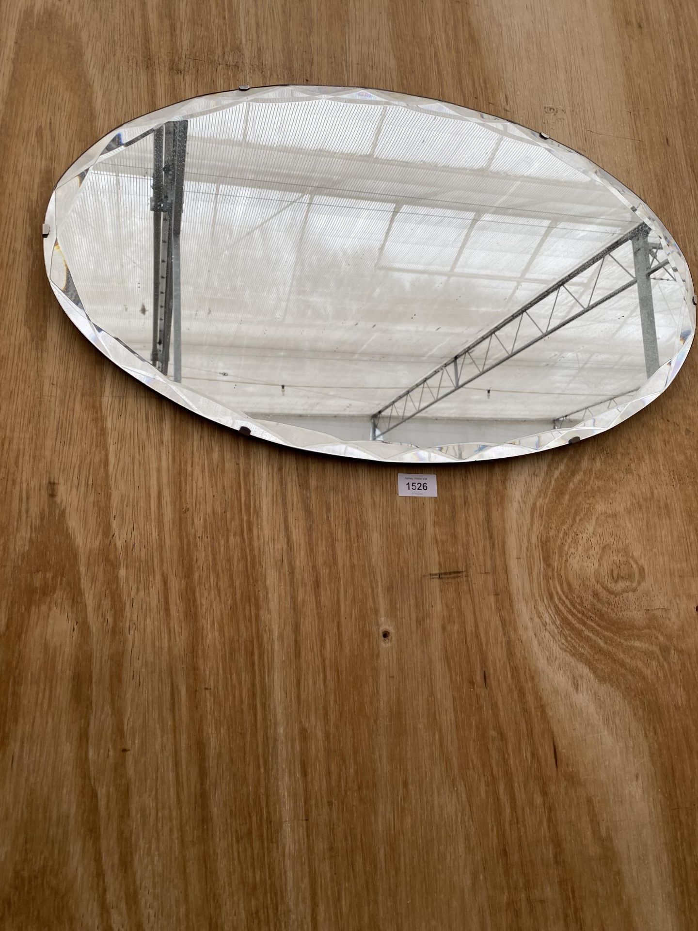AN OVAL ART DECO UNFRAMED BEVELED EDGE WALL MIRROR WITH HANGING CHAIN