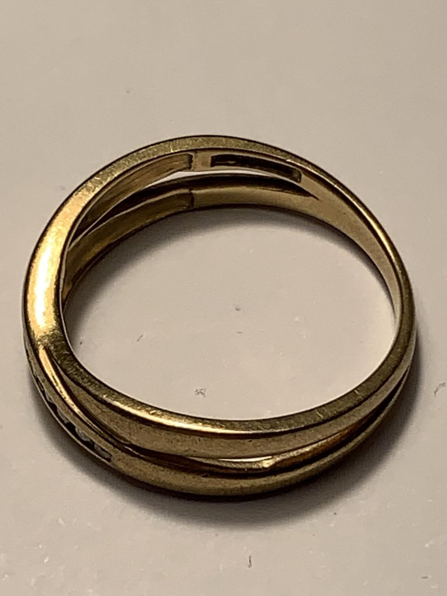 A 9 CARAT GOLD RING IN A CROSSOVER DESIGN SIZE N/0 - Image 2 of 3