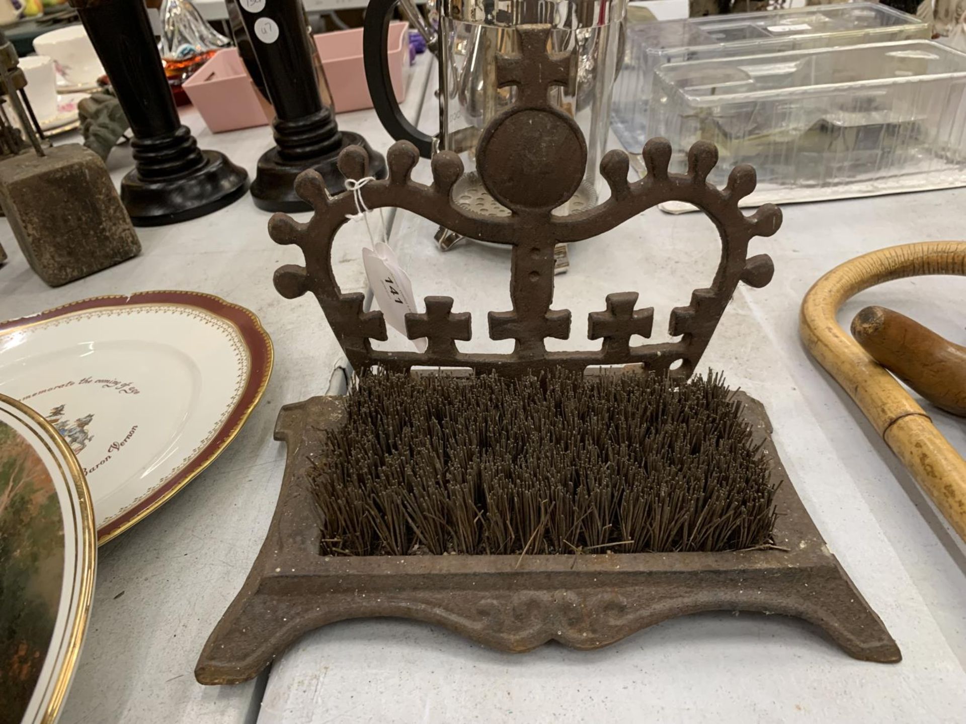 A VINTAGE CAST IRON BOOT SCRAPER WITH A CROWN TO THE TOP