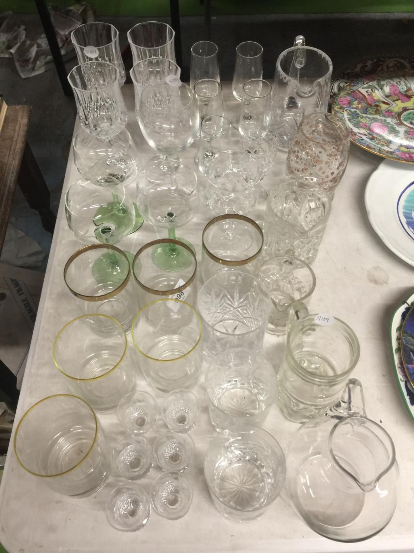 A QUANTITY OF GLASSWARE TO INCLUDE WINE GLASSES, TUMBLERS, SHOT GLASSES, ETC.,