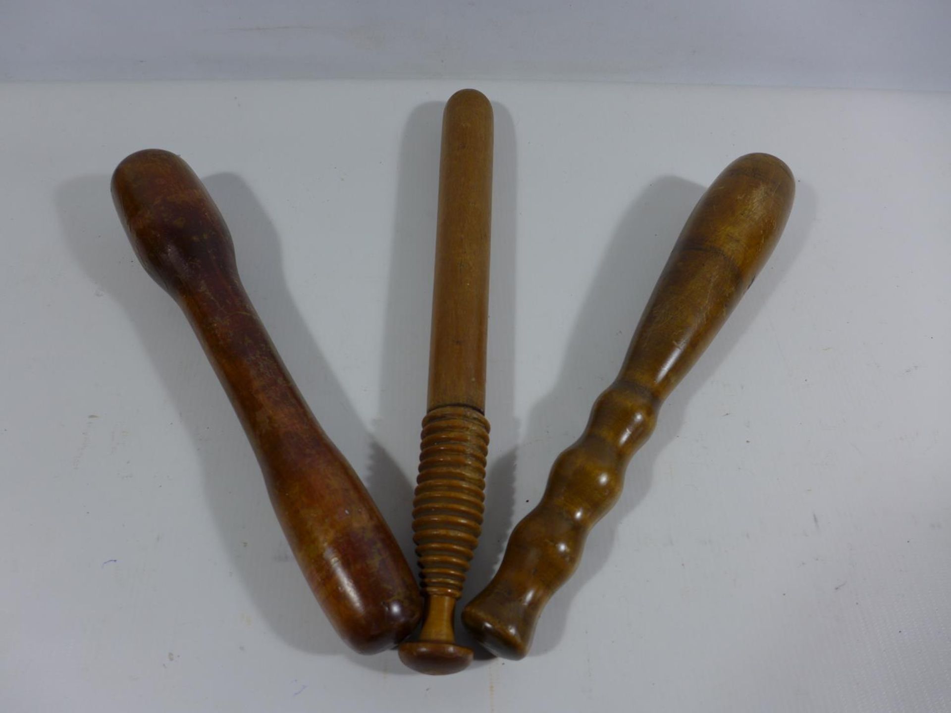 THREE ASSORTED WOODEN CLUBS, LENGTHS 29CM AD 32.5CM