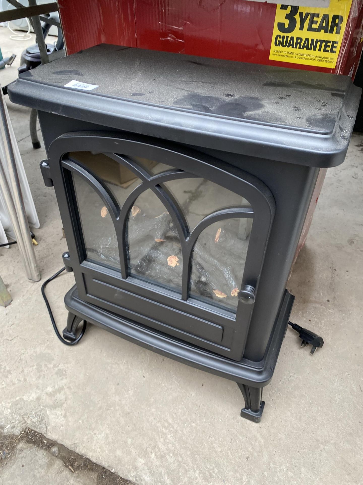 A BLACK ELECTRIC HEATER IN THE FORM OF A LOG BURNER