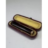 A GOLD TOPPED CHEROOT HOLDER IN A PRESENTATION BOX