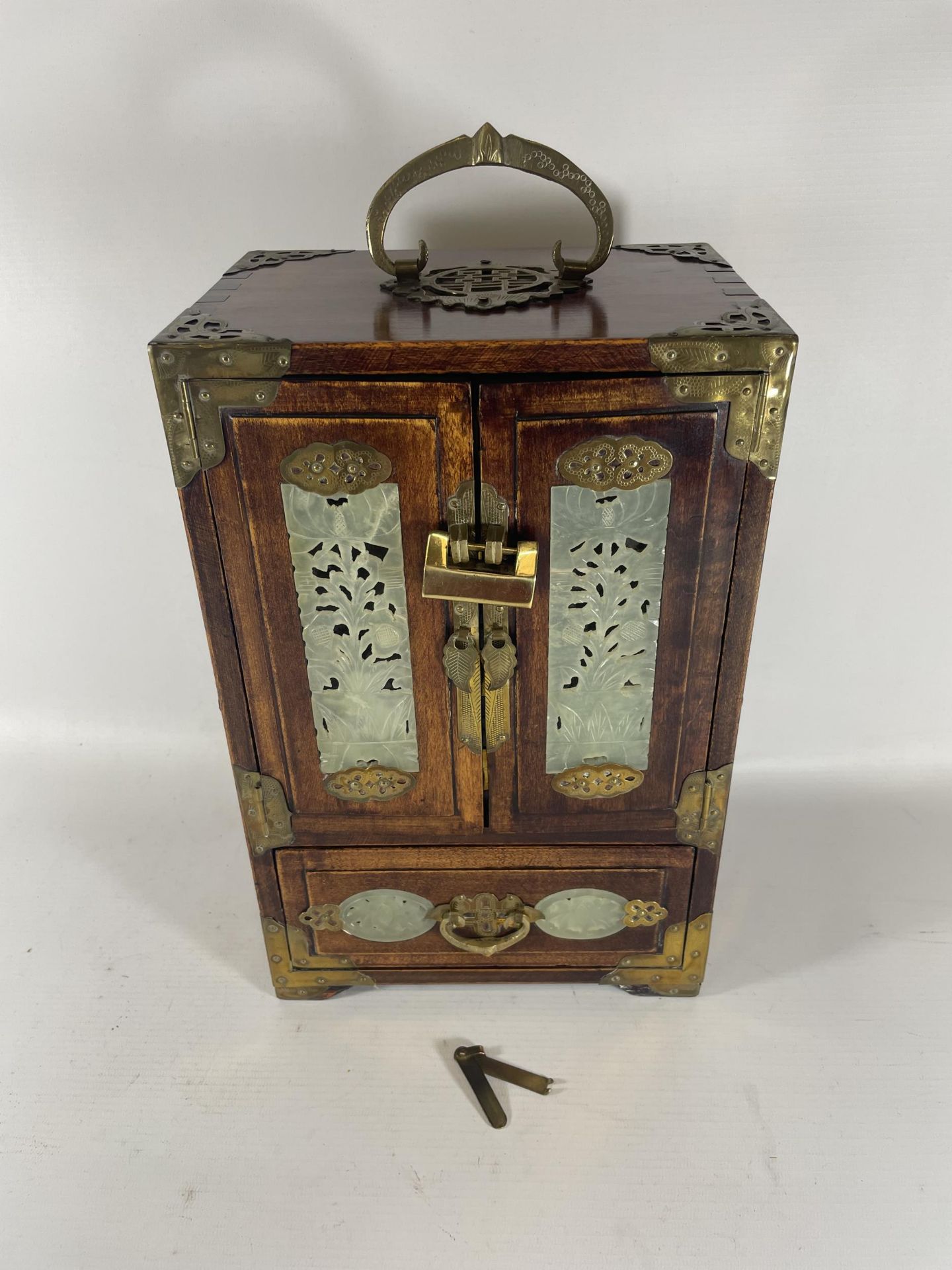 A VINTAGE ORIENTAL HARDWOOD JEWELLERY BOX WITH BRASS FITTINGS AND JADE TYPE PANELLED DESIGN WITH