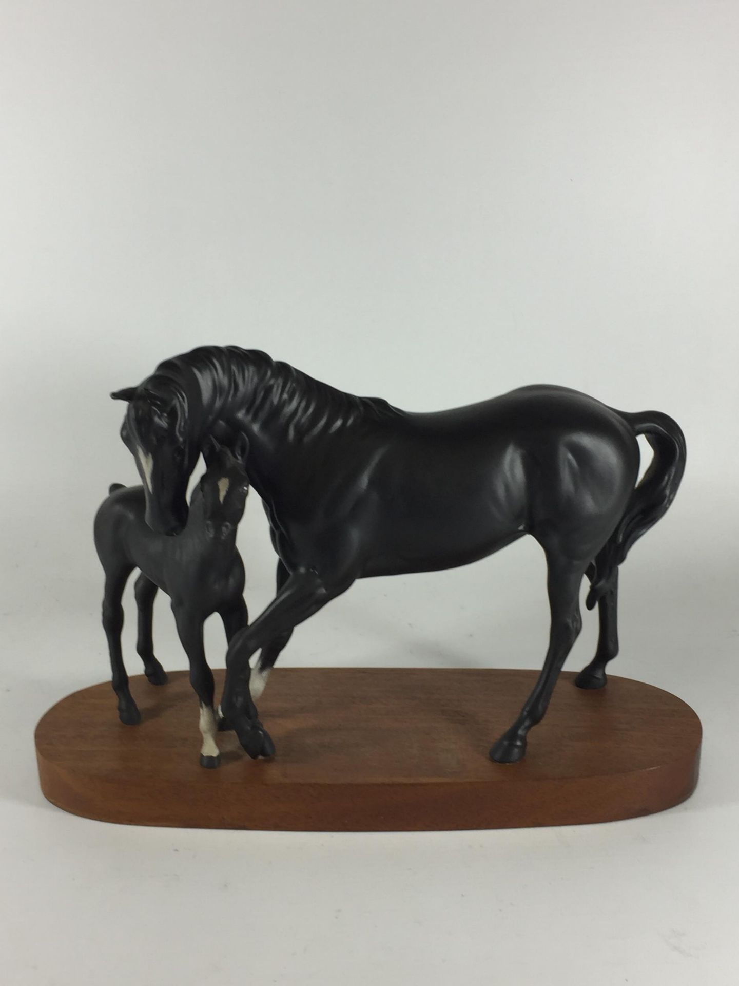 A ROYAL DOULTON BLACK BEAUTY AND FOAL HORSE FIGURE GROUP ON WOODEN PLINTH BASE