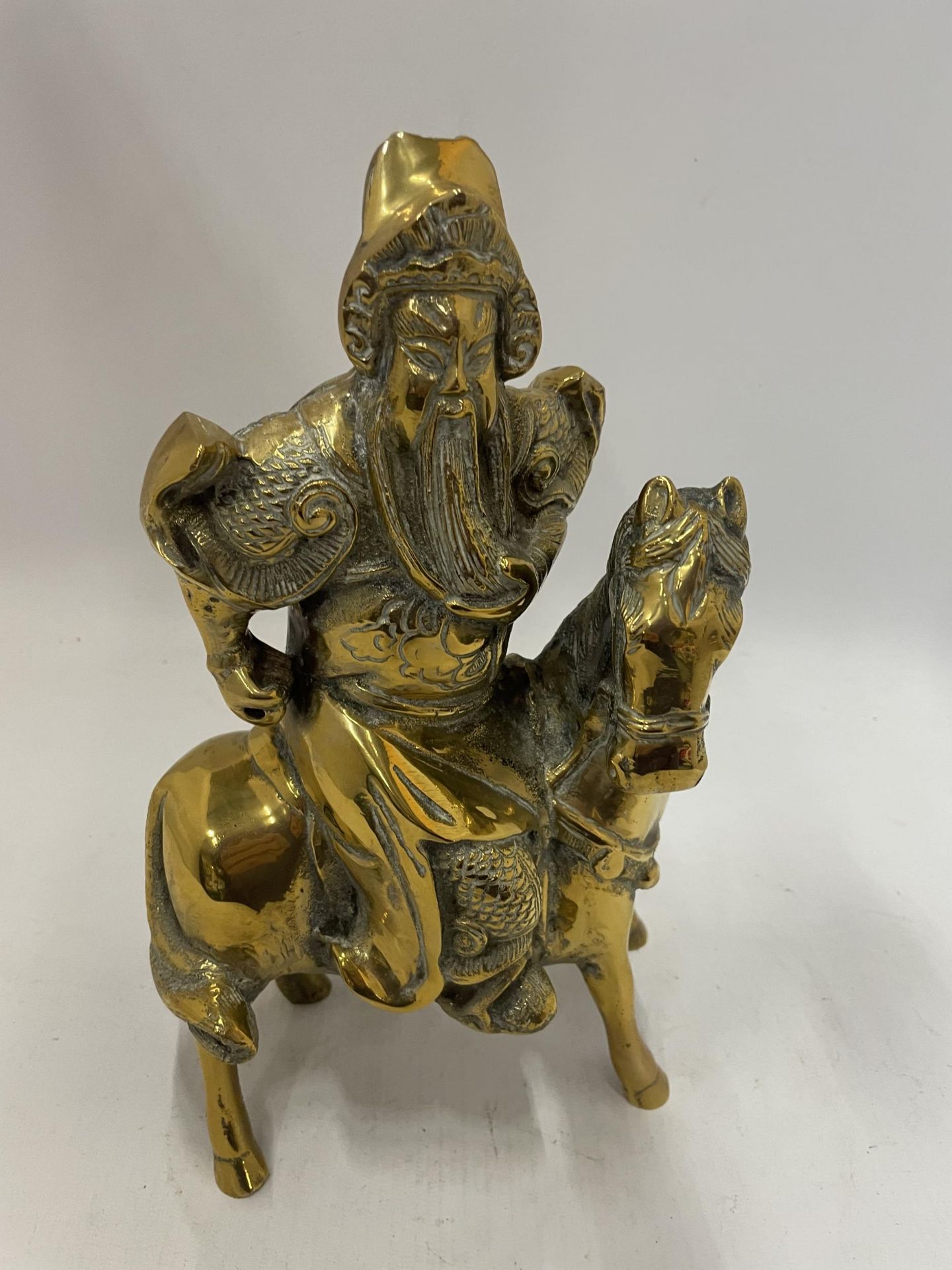 AN ORIENTAL BRASS FIGURE OF A WARRIOR ON HORSEBACK