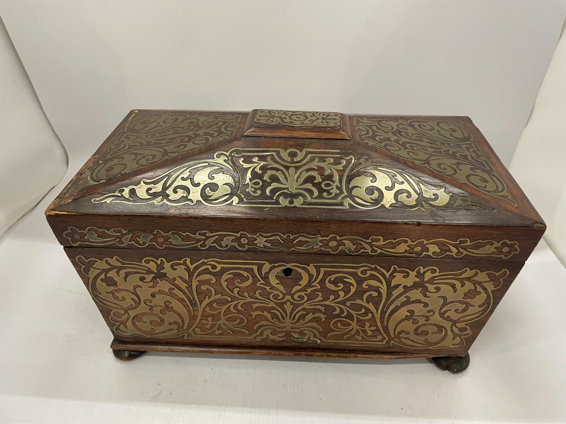 A 19TH CENTURY ROSEWOOD AND BRASS INLAID SARCOPHAGUS SHAPED TEA CADDY WITH TWO INNER LIDDED