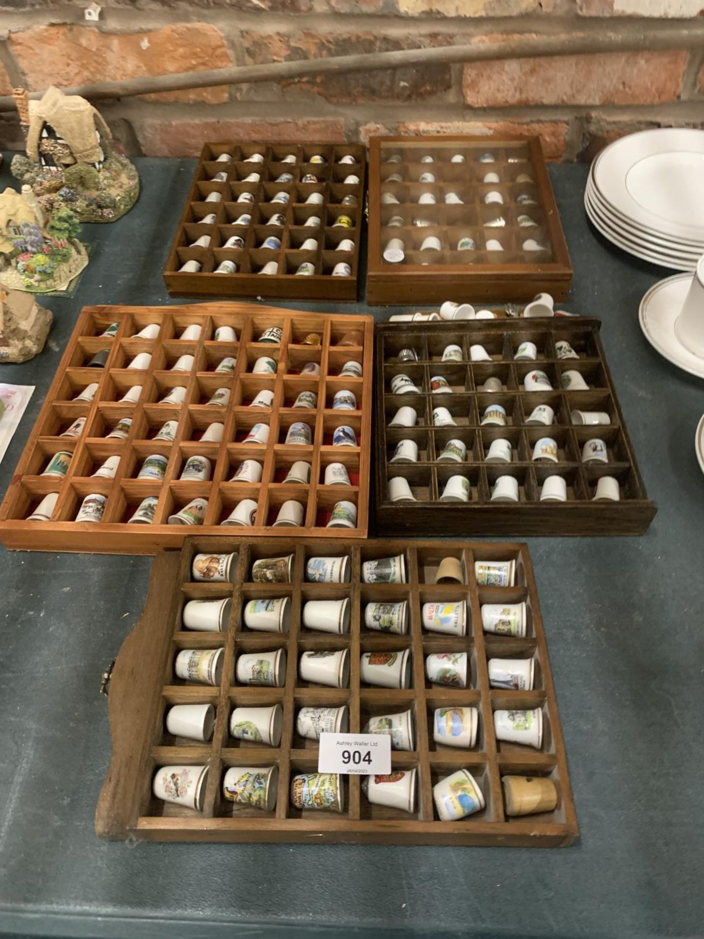 A LARGE QUANTITY OF COLLECTABLE CERAMIC AND CHINA THIMBLES IN FIVE DISPLAY STANDS