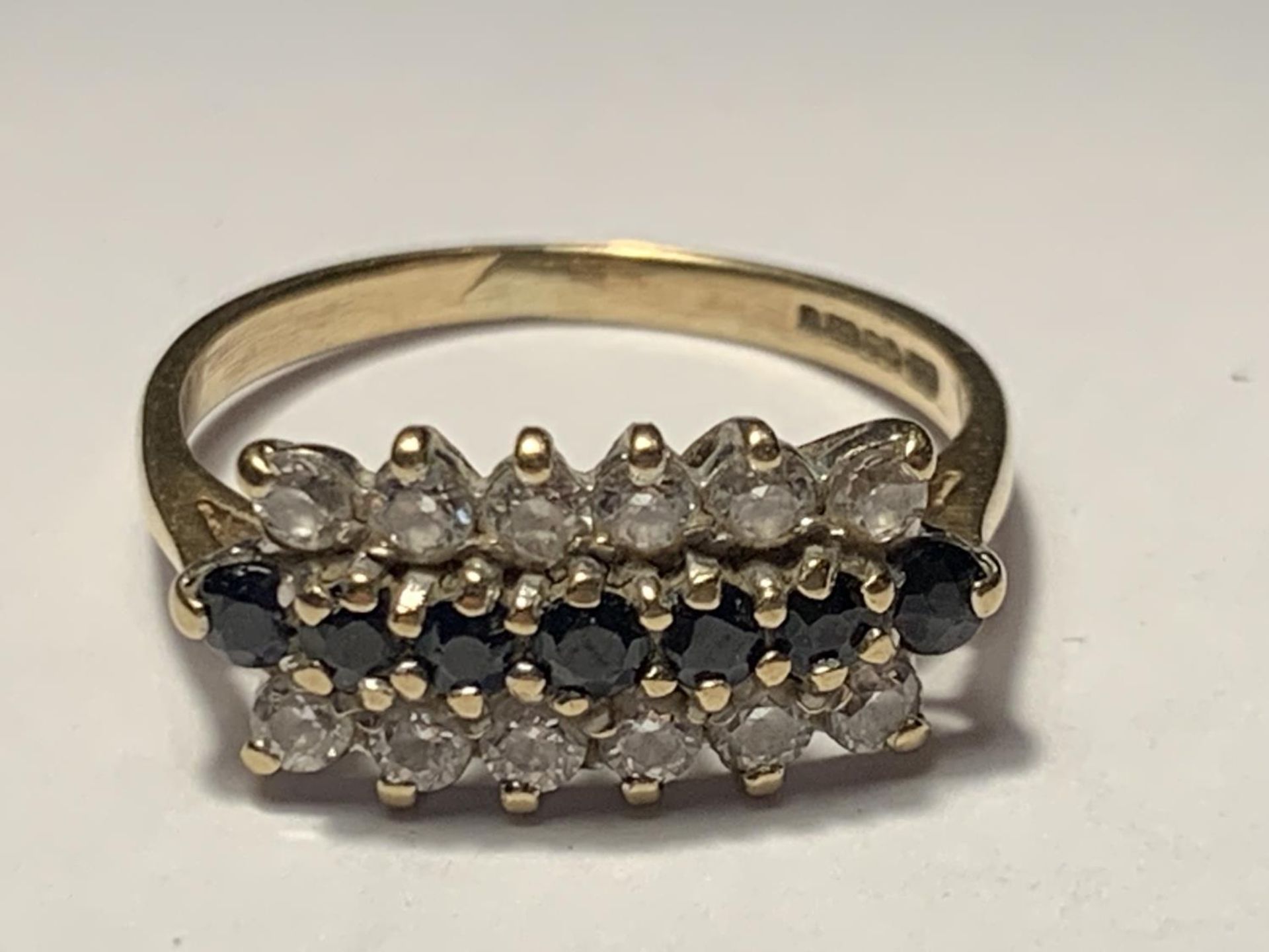 A 9 CARAT GOLD RING WITH TEN SAPPHIRES AND TWELVE CUBIC ZIRCONIAS SIZE K/L