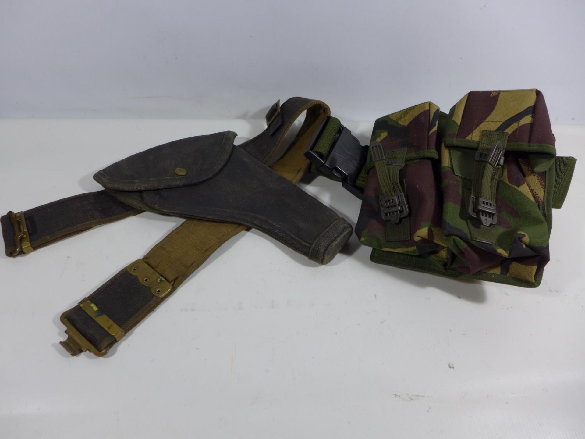 A MILITARY ISSUE CANVAS BELT AND HOLSTER AND A CAMOUFLAGE BELT PACK (2)