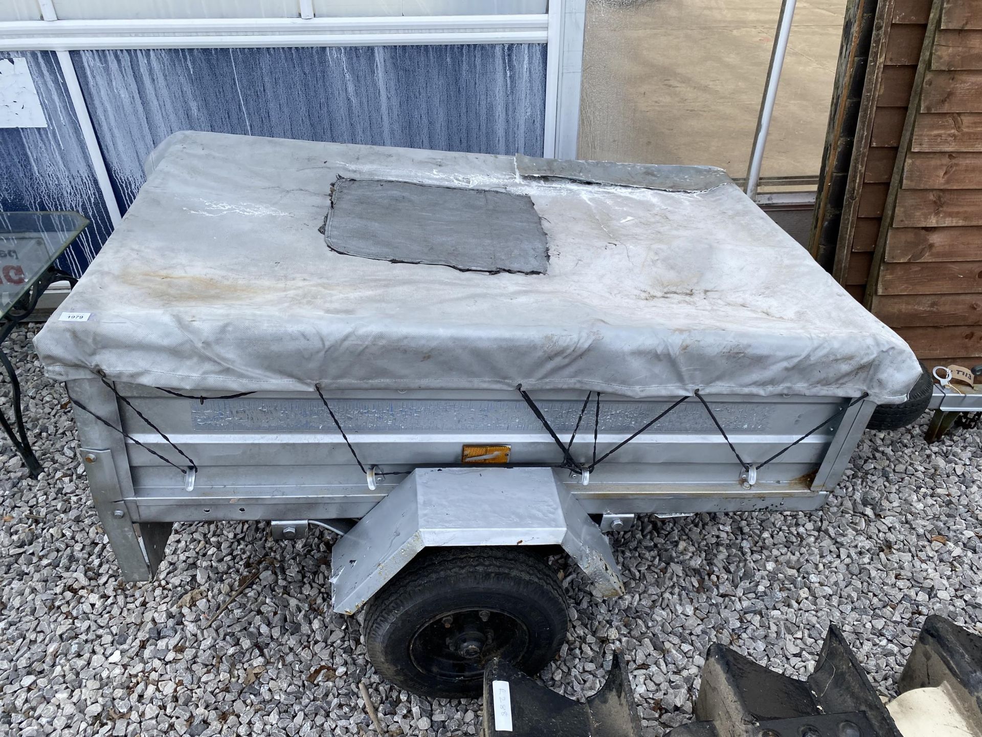 A SMALL METAL CAR TRAILER AND COVER
