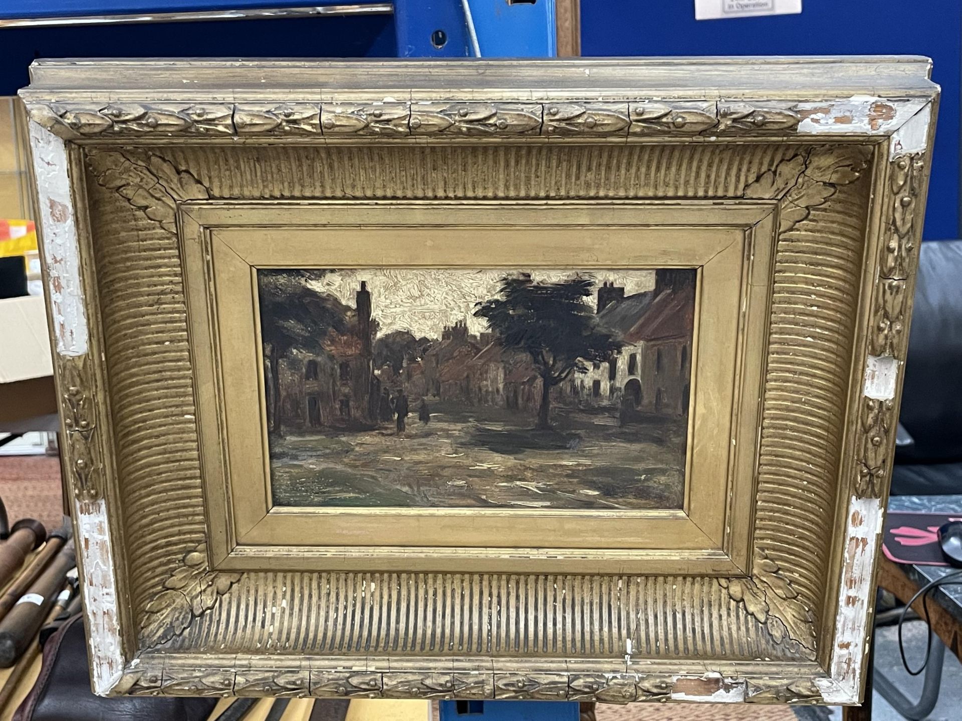 AN ANTIQUE GILT FRAMED OIL PAINTING OF A VILLAGE SCENE, UNSIGNED