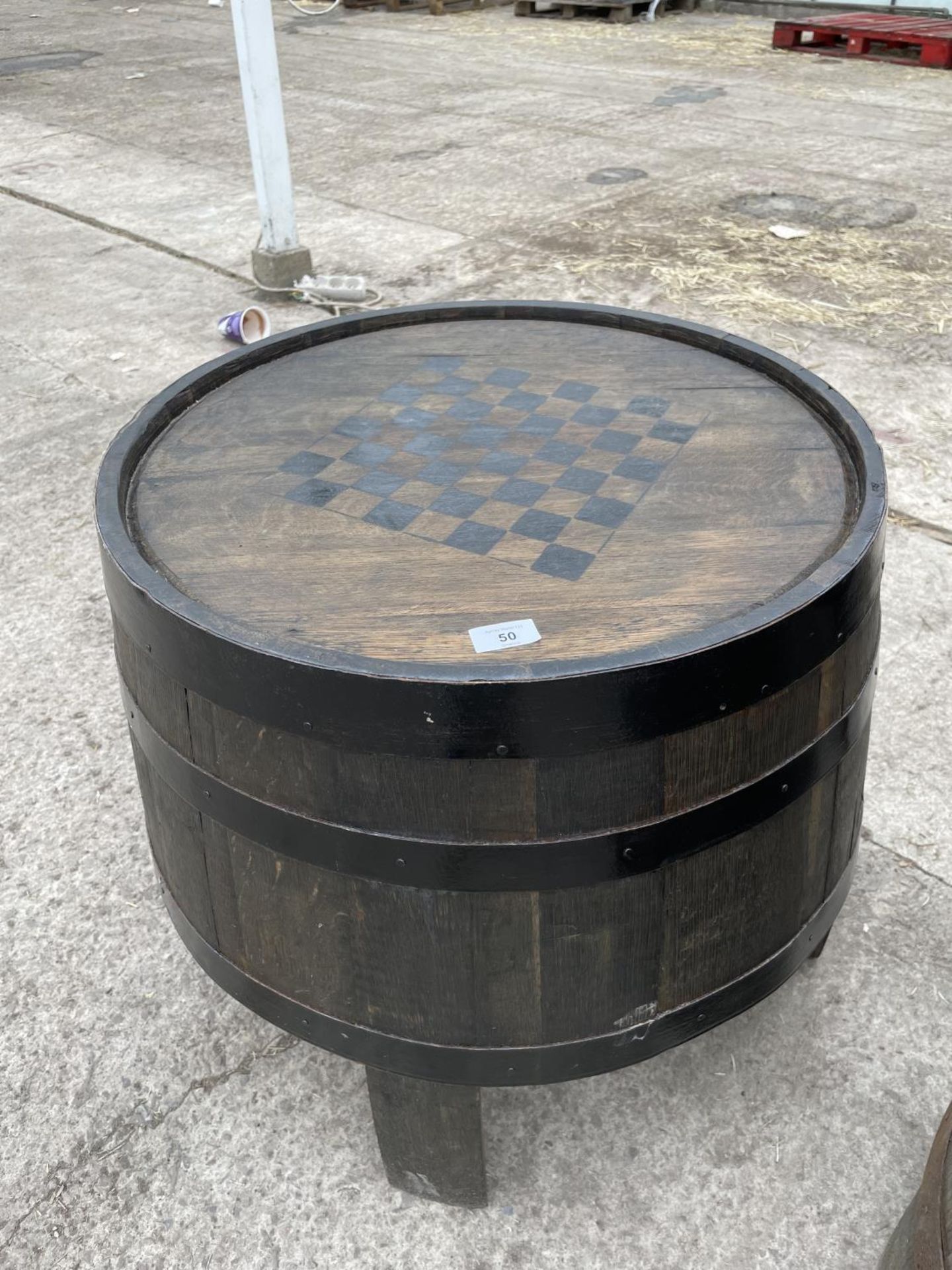 A TABLE MADE FROM AN OAK BARREL MARKED WITH A CHESS/DRAUGHT BOARD - NO VAT