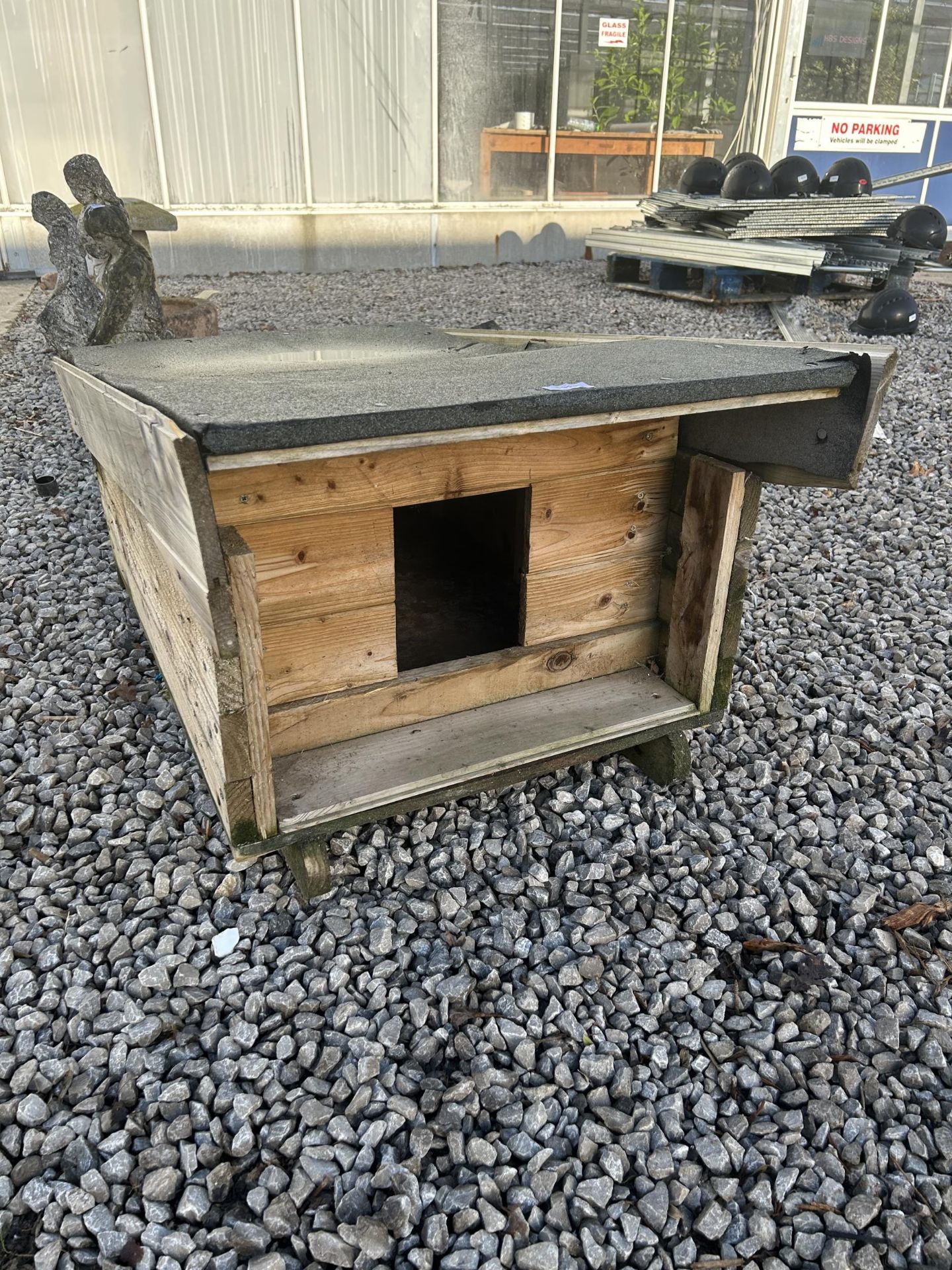 A WOODEN RABBIT HUTCH WITH FELT ROOF