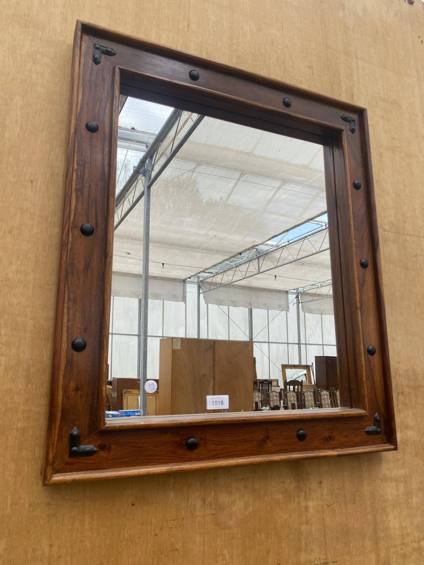 A DECORATIVE WOODEN FRAMED WALL MIRROR