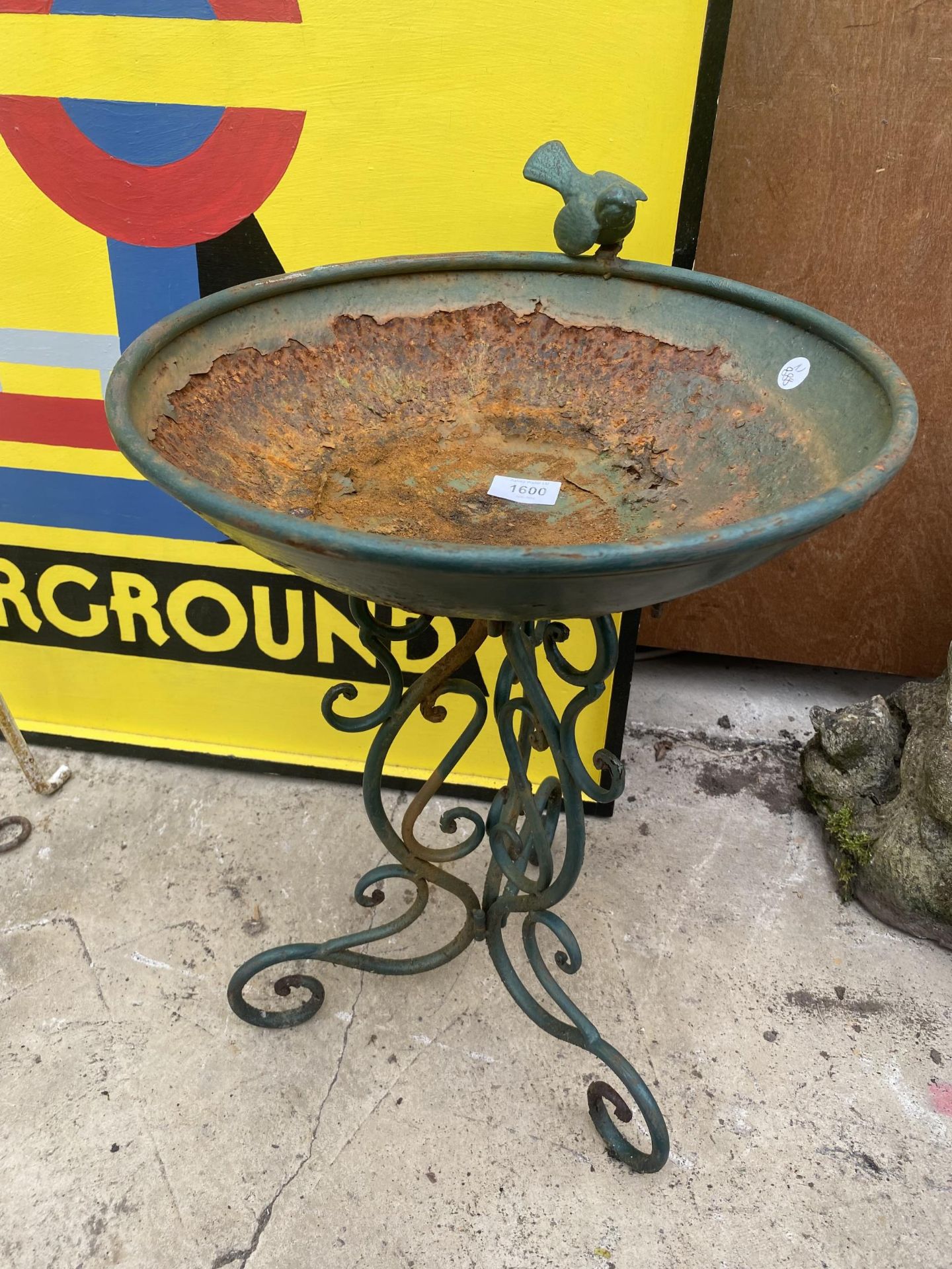 A METAL BIRD BATH WITH SMALL BIRD DETAIL