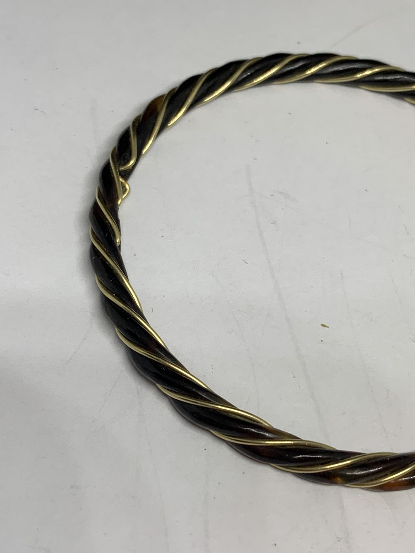 A BLACK BANGLE WITH A TESTED TO 14 CARAT GOLD WIRE TWISTED THROUGH IT AND A PAIR OF MATCHING - Image 2 of 3