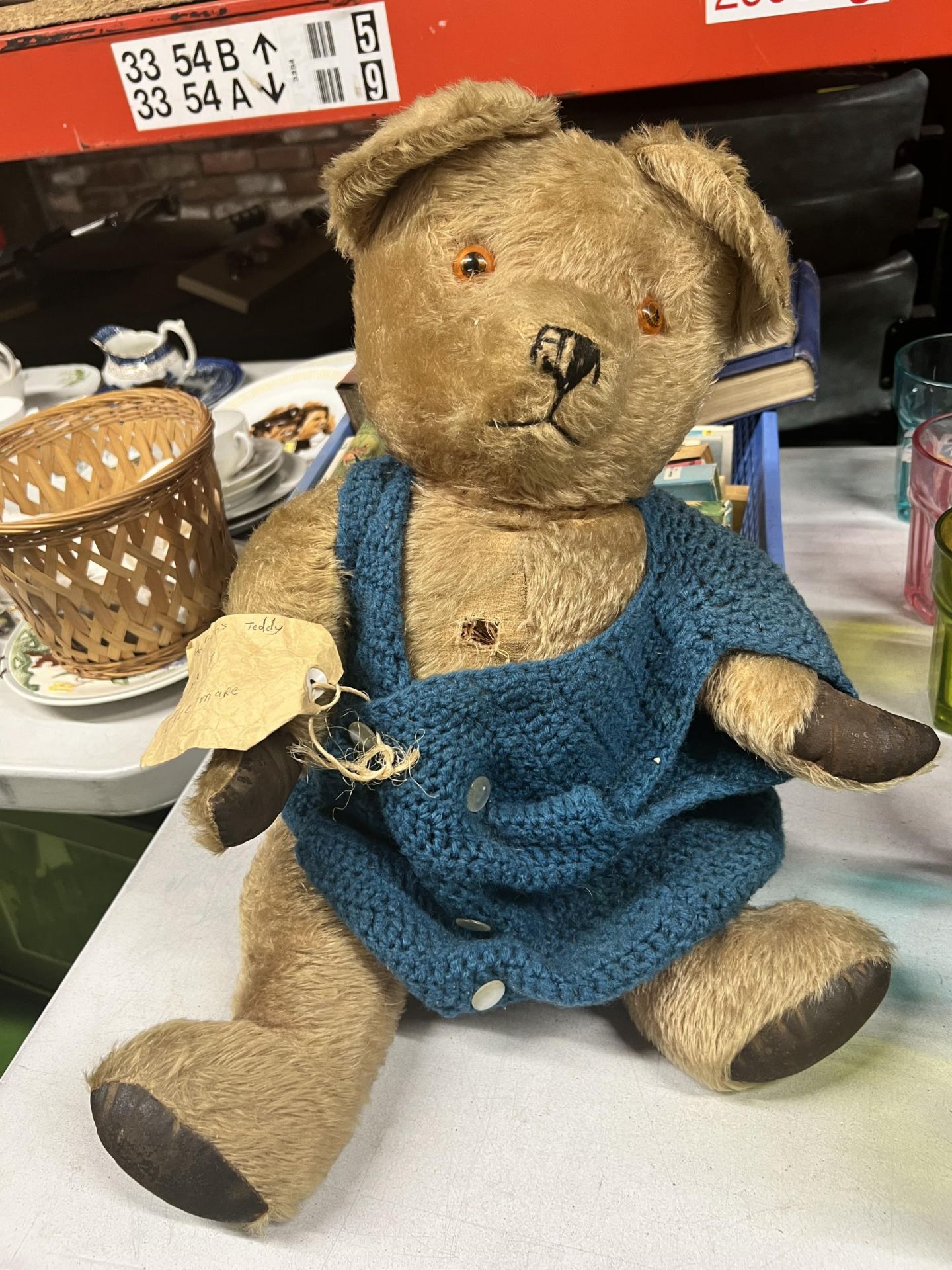 A VERY WELL LOVED VINTAGE TEDDY BEAR, STRAW FILLED, AS OWNED BY HANNAH, AGE 7