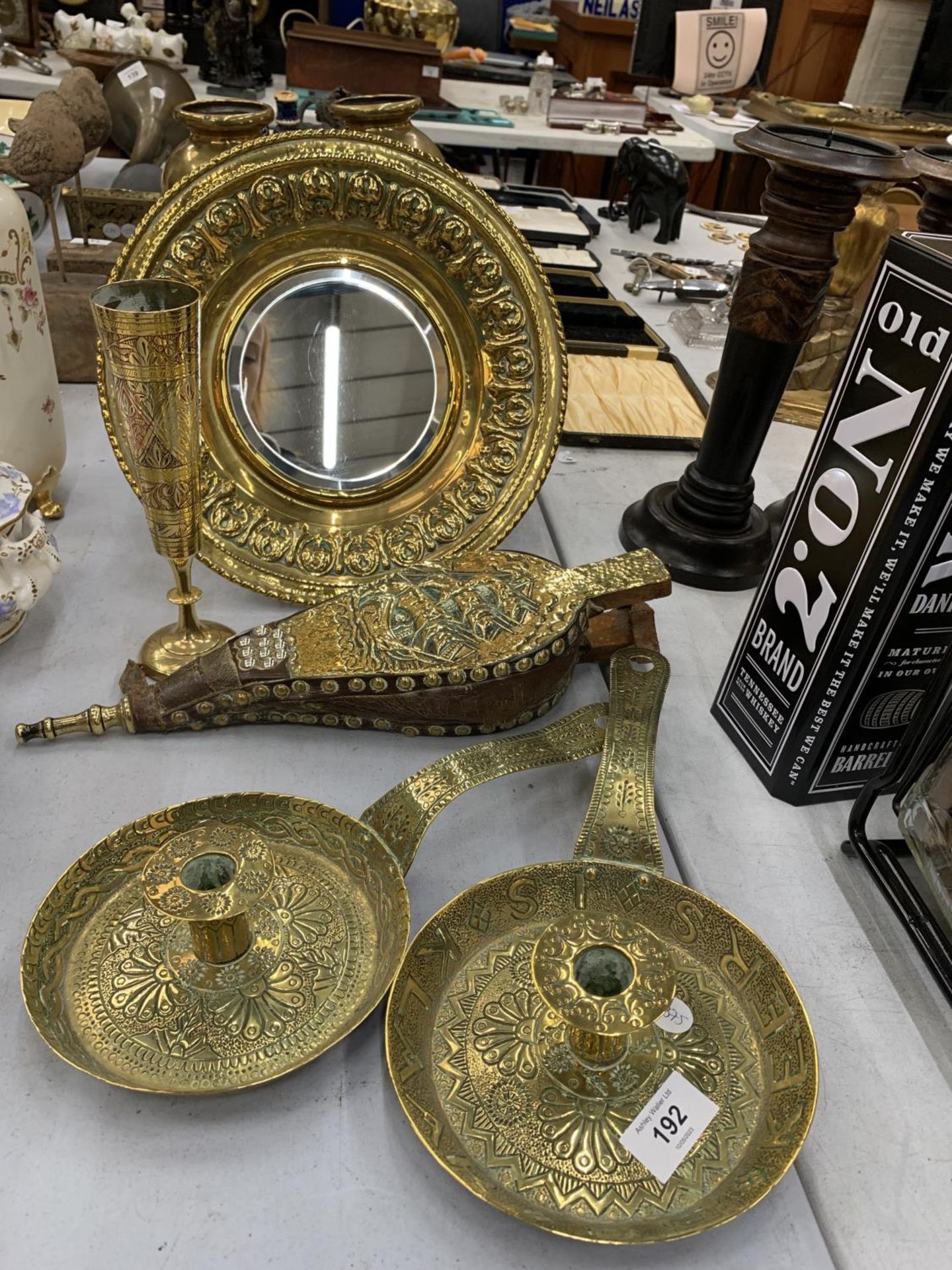 A BRASS MIRROR WITH EMBOSSED FRAME DIAMETER 31CM, TWO VINTAGE CANDLE HOLDERS WITH DECORATION AND