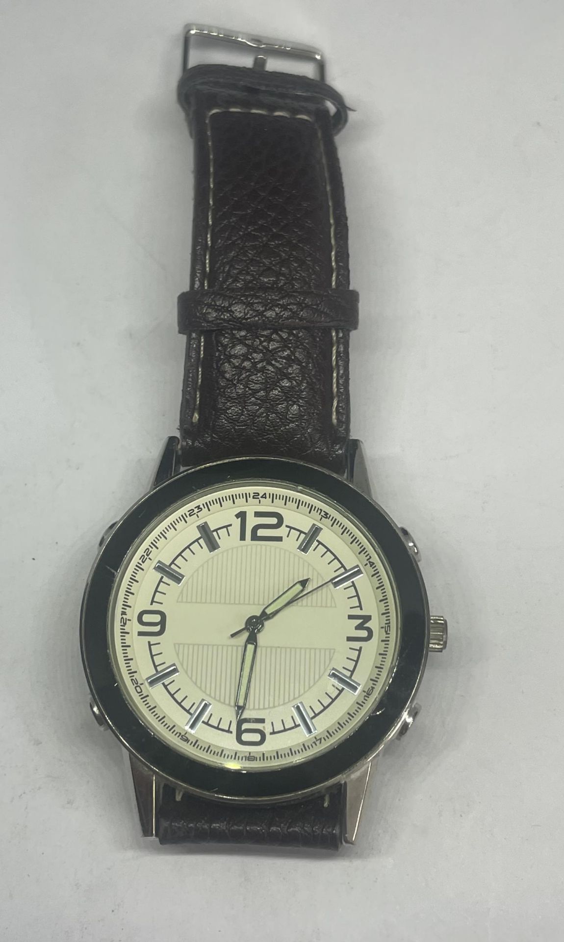 A WRIST WATCH WITH A BROWN LEATHER STRAP SEEN WORKING BUT NO WARRANTY