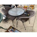 A ROUND GLASS TOPPED BISTRO TABLE AND TWO RATTAN STYLE CHAIRS