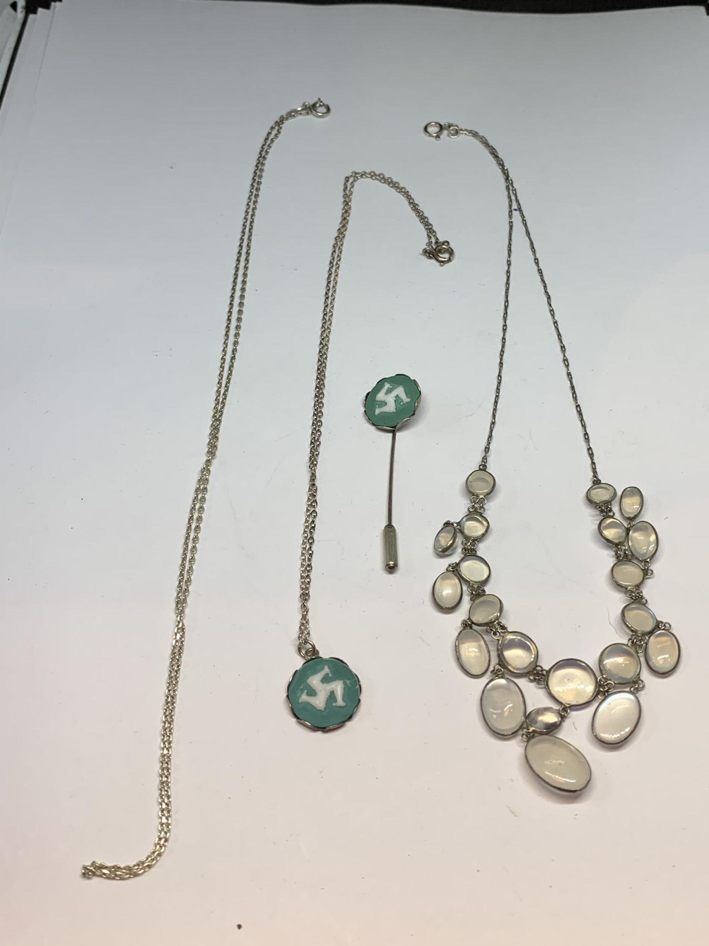 THREE SILVER NECKLACES ONE WITH AN ISLE OF MAN DESIGN PENDANT AND MATCHING PIN STICK