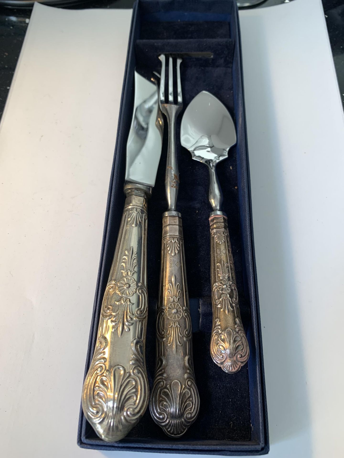 THREE HALLMARKED SILVER HANDLED ITEMS TO INCLUDE A KNIFE, FORK AND SPOON IN A PRESENTATION BOX