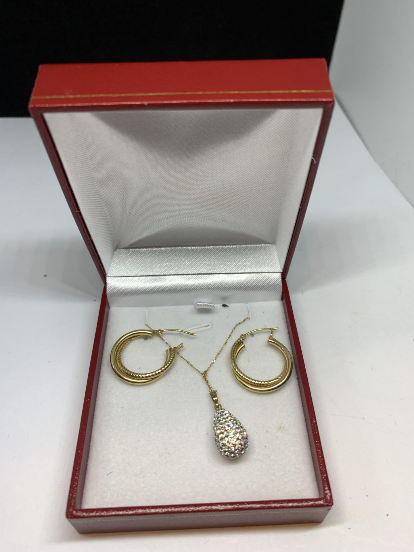 A PAIR OF 14 CARAT GOLD EARRINGS AND A 9 CARAT GOLD NECKLACE WITH CLEAR STONE DROP PENDANT IN A