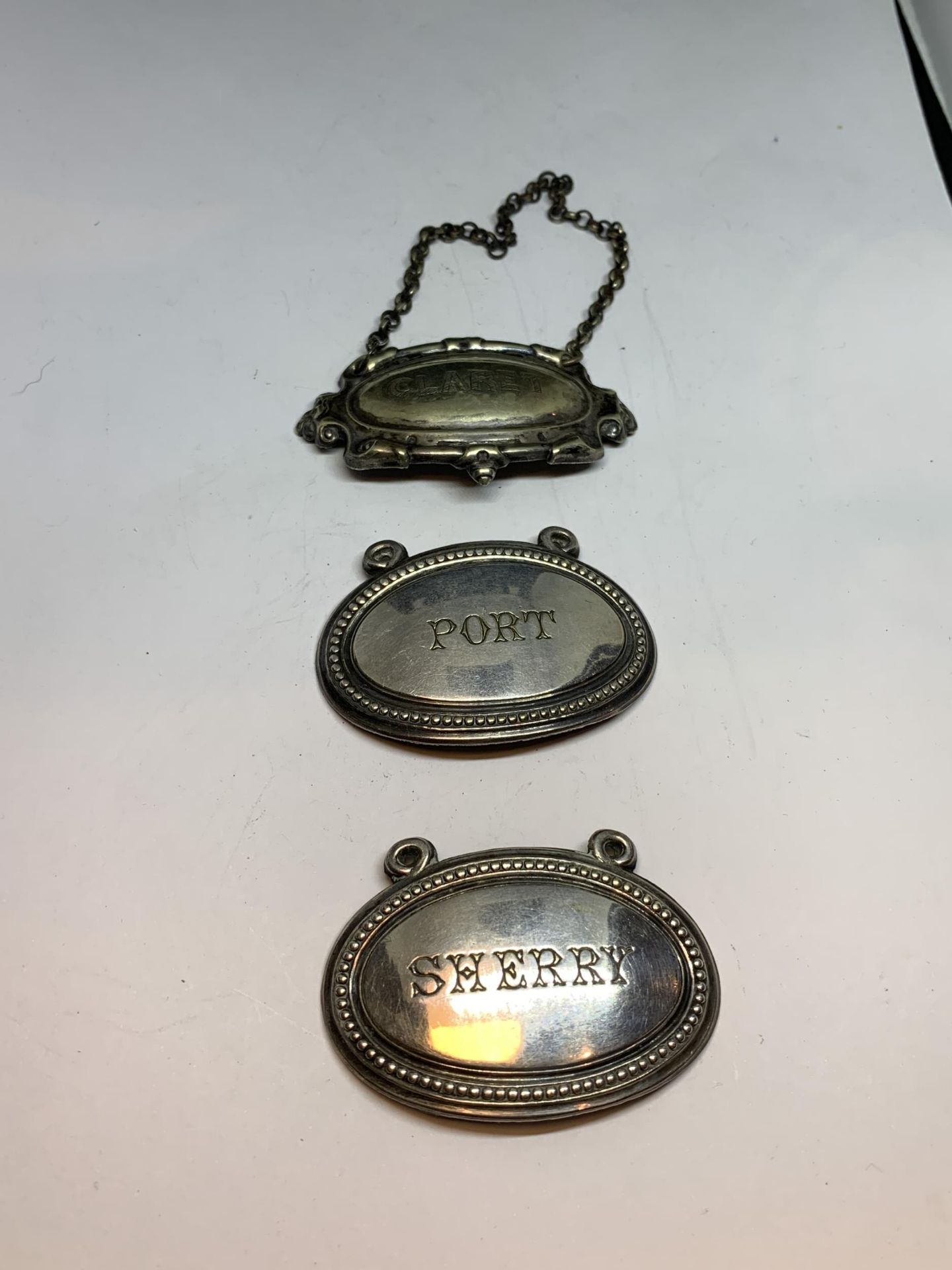 THREE WHITE METAL DECANTER LABELS