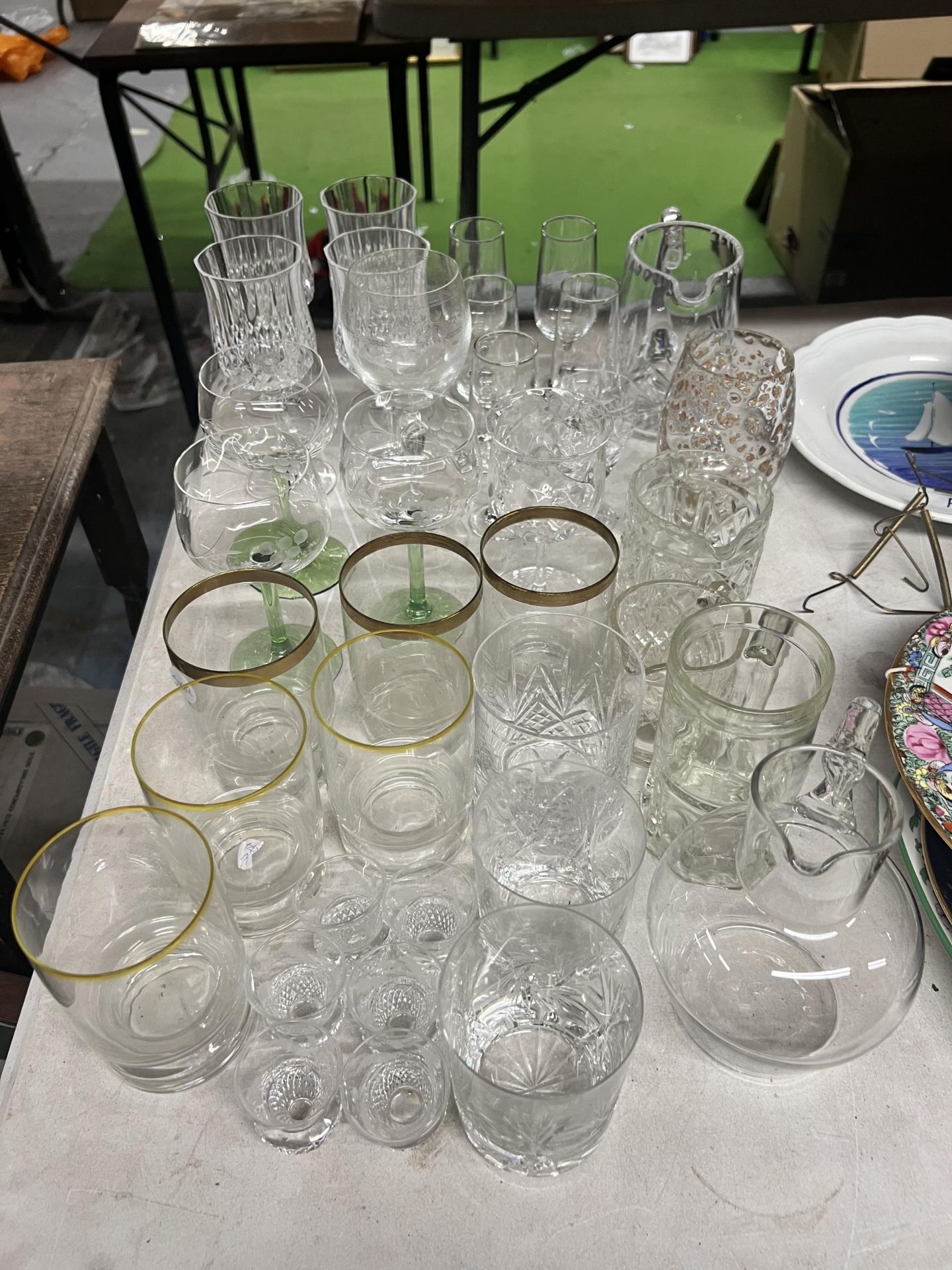 A QUANTITY OF GLASSWARE TO INCLUDE WINE GLASSES, TUMBLERS, SHOT GLASSES, ETC.,