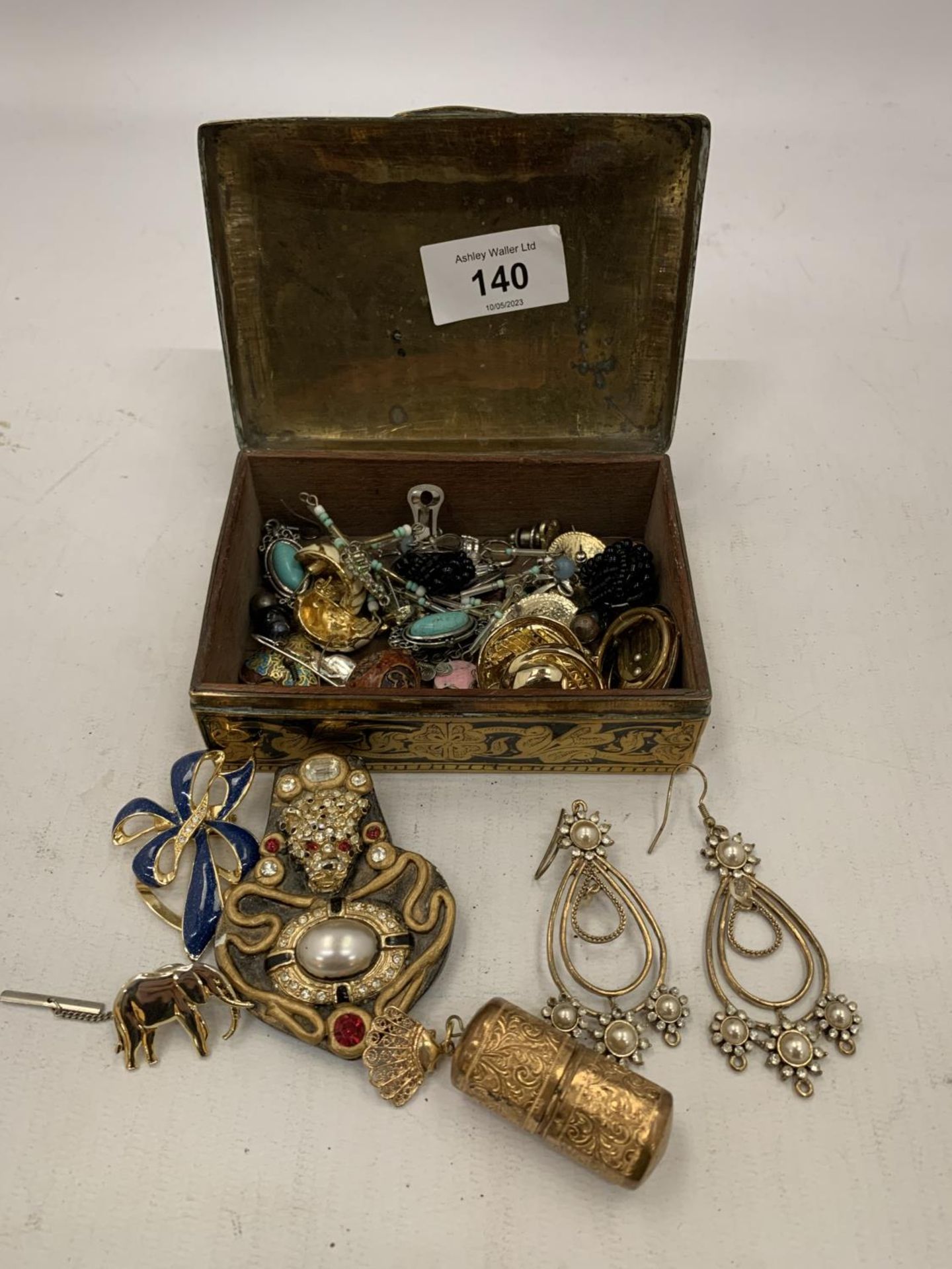 A SMALL BRASS BOX CONTAINING A QUANTITY OF COSTUME JEWELLERY