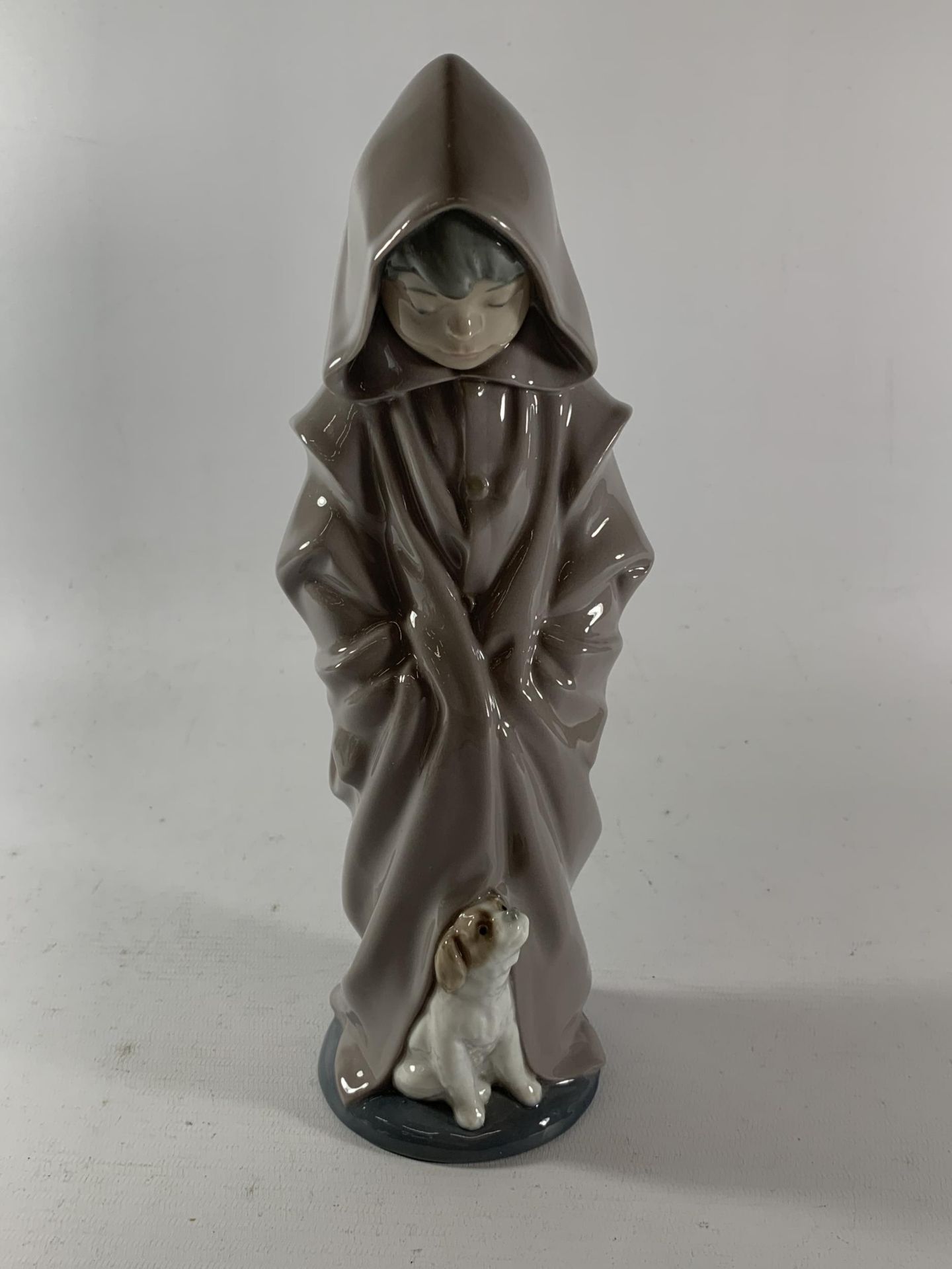 A NAO FIGURE OF A BOY IN ROBE WITH A DOG