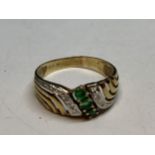 A 9 CARAT GOLD RING WITH THREE GREEN STONEES SORROUNDED BY CLEAR STONES GROSS WEIGHT 2 GRAMS SIZE P