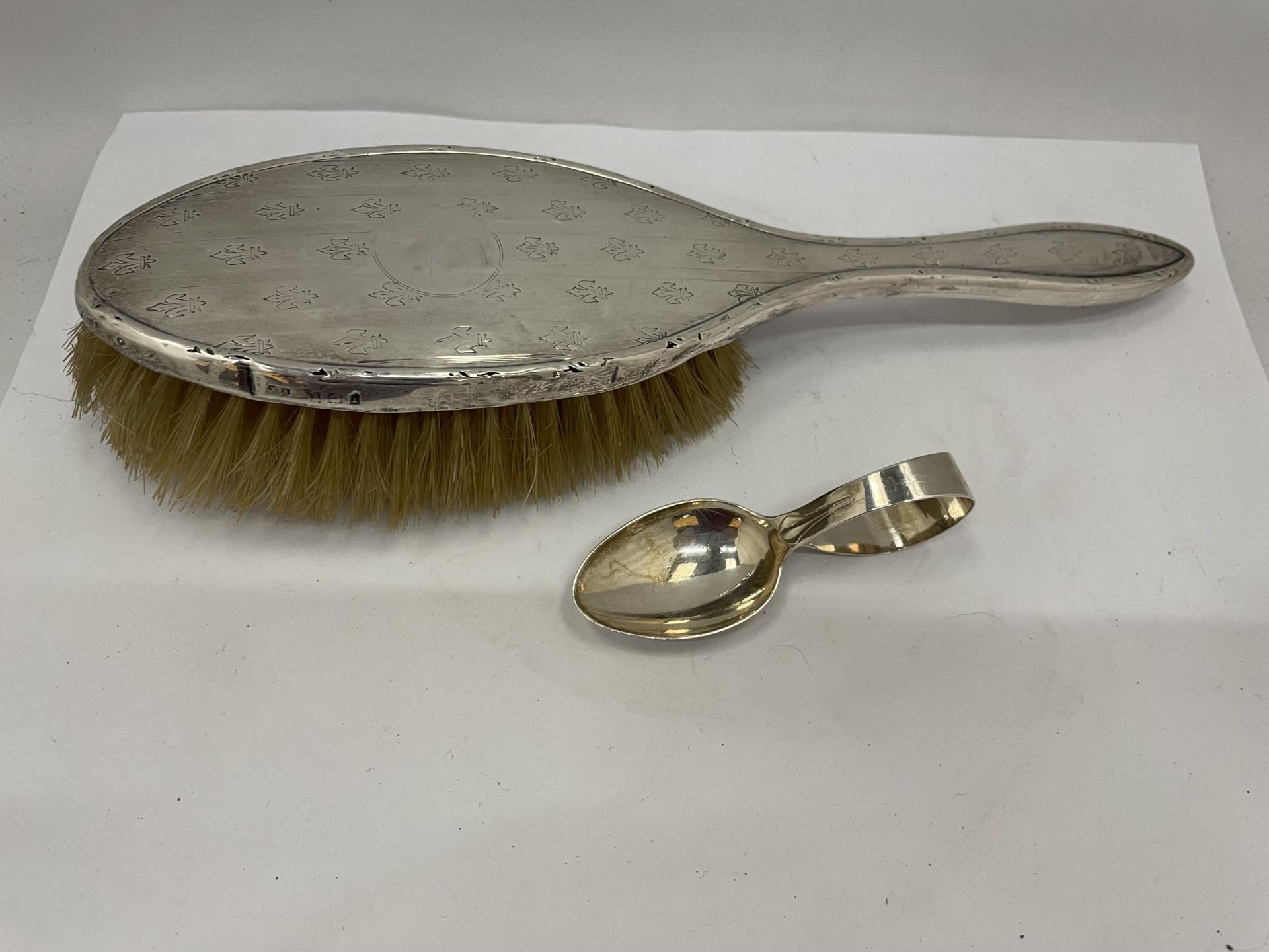 A HALLMARKED SILVER BABY'S SPOON AND SILVER BACKED BRUSH