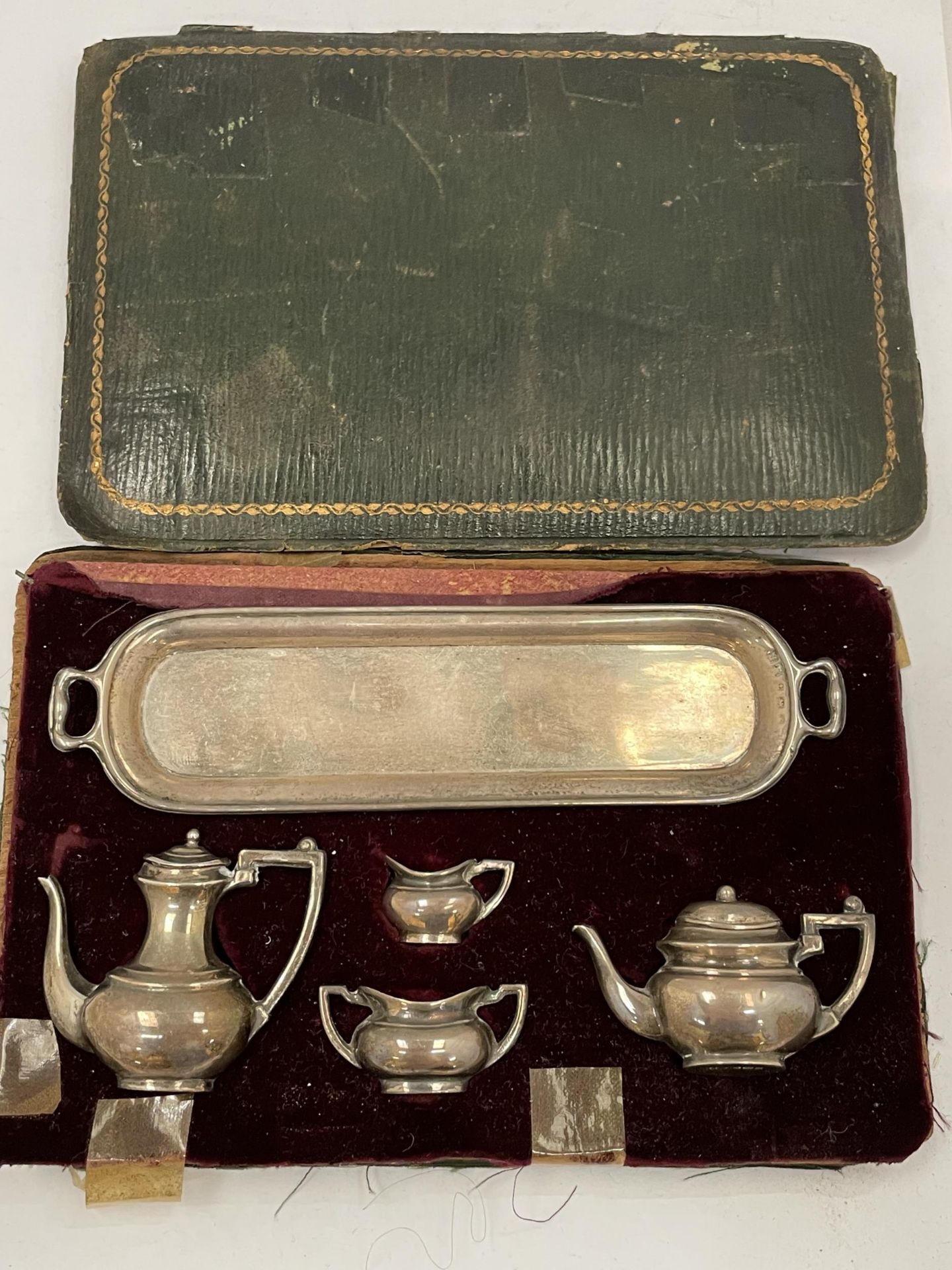 A MINIATURE 1920'S HALLMARKED SILVER TEA SET IN CASE (CASE A/F)